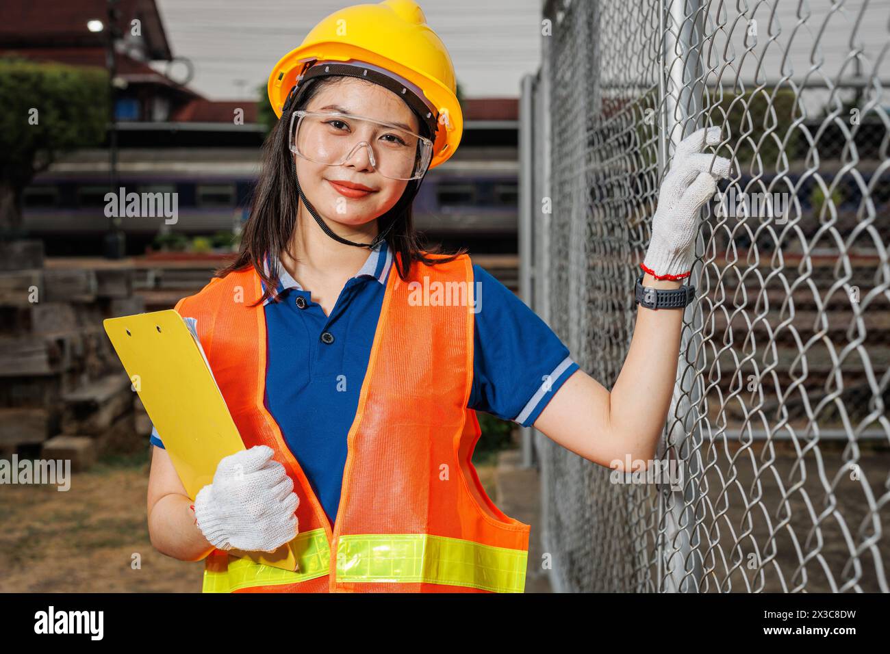 portrait jeune travailleuse debout sourire heureux avec casque de sécurité. une dame employée intelligente travaillant dans l'industrie. Banque D'Images