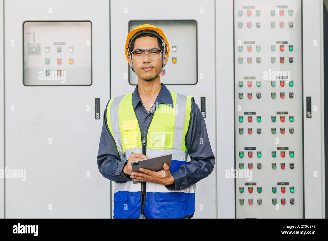 L'ingénieur électricien masculin asiatique travaille debout au système d'alimentation de pompage de l'eau de refroidissement de l'armoire de commutation principale. Banque D'Images