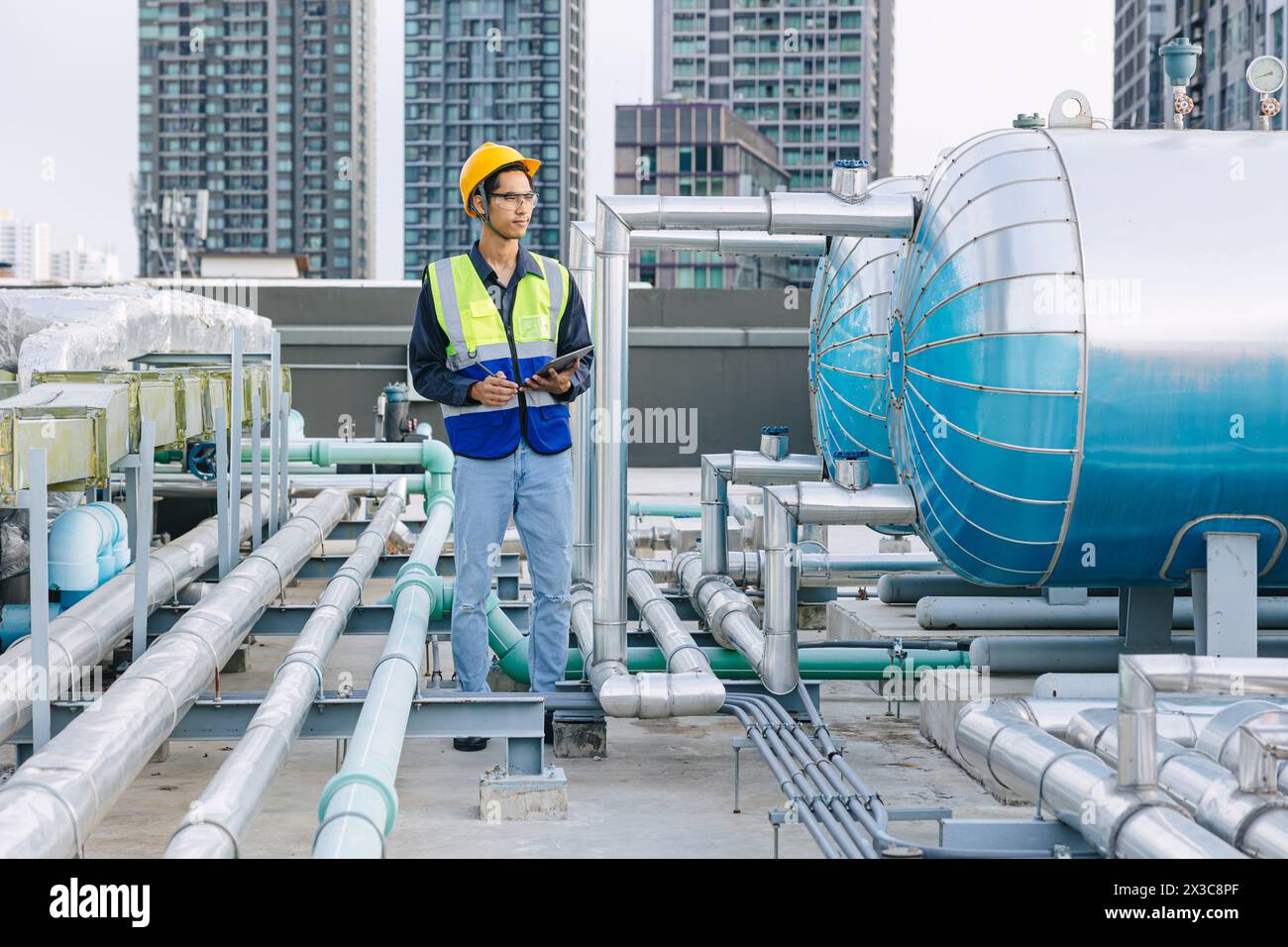 ingénieur technicien masculin travaillant le système de tuyau d'alimentation en eau chaude de réservoir de chaudière d'hôtel de service. homme contrôle la sécurité de l'entretien de l'eau de chauffage de canalisation Banque D'Images