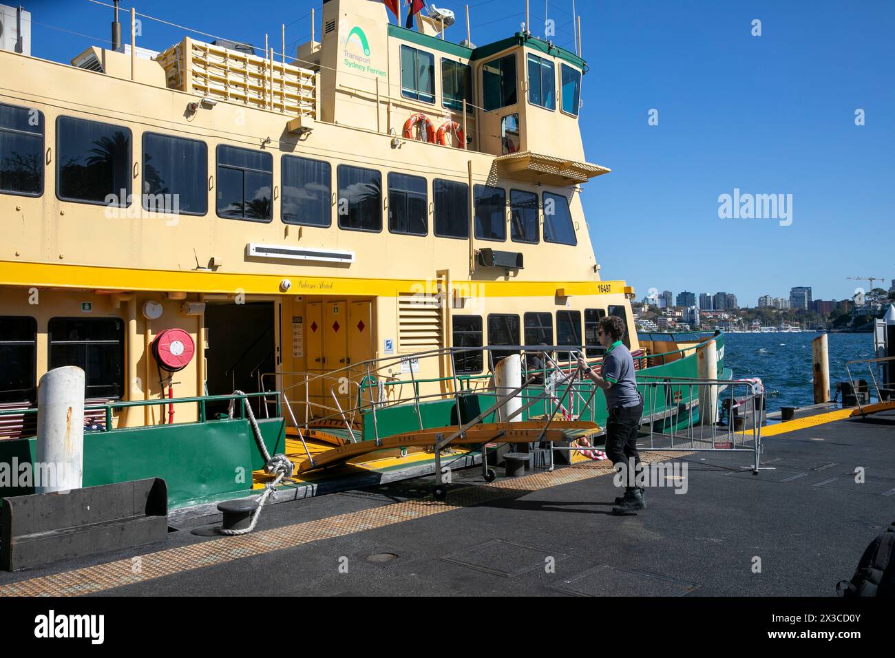 Sydney ferry Golden Grove au quai de ferry de Cremorne point, l'employé du ferry positionne la passerelle d'accès pour que les gens puissent débarquer, Sydney, Australie Banque D'Images