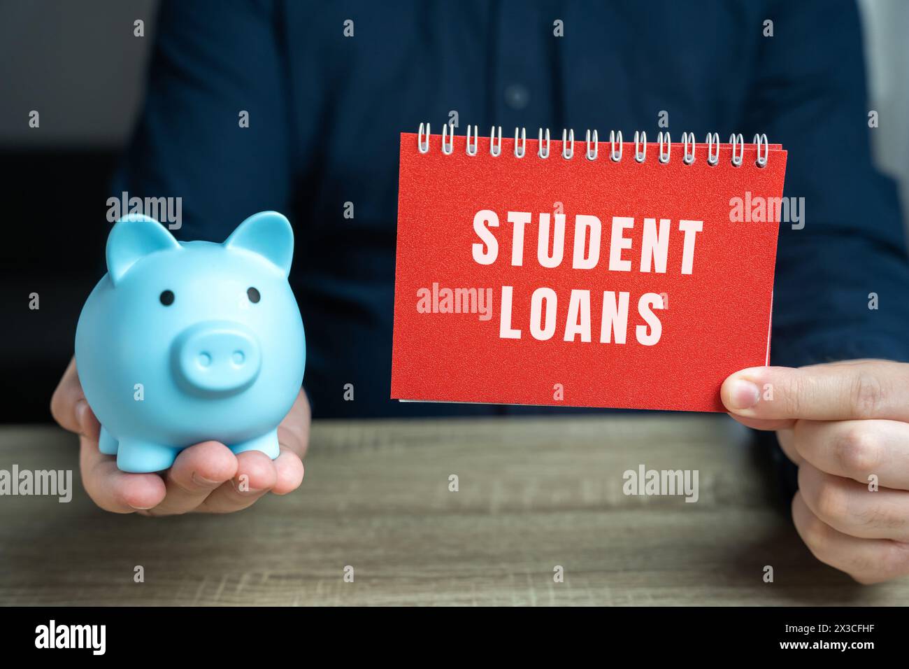 Concept de prêts étudiants. Aide financière accordée aux étudiants pour les aider à couvrir le coût de l'enseignement supérieur. Note dans les mains des mâles et tirelire de porc Banque D'Images