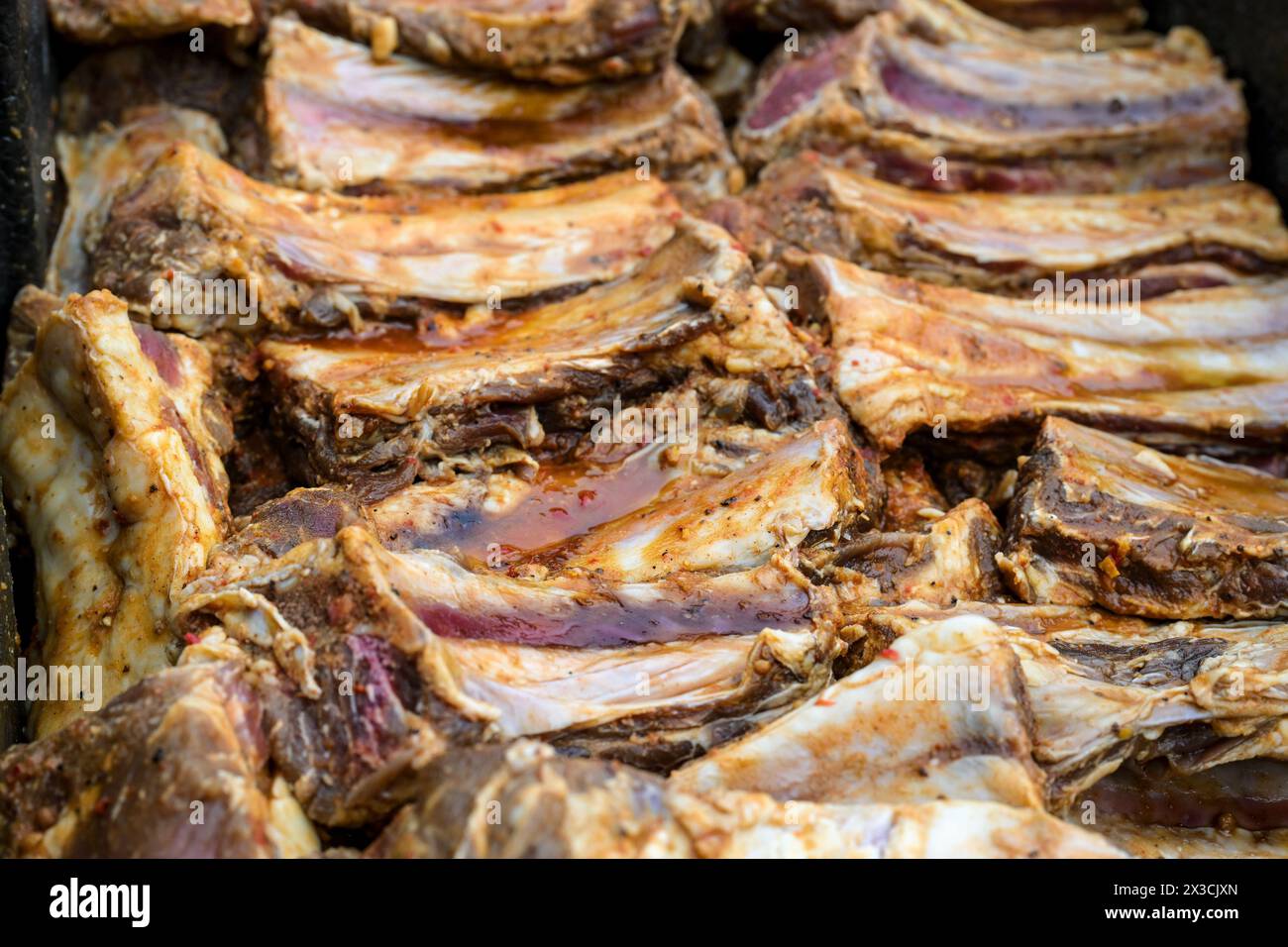Beaucoup de côtes courtes de bœuf assaisonnées et marinées côte à côte, préparation pour un grand barbecue, foyer sélectionné, profondeur de champ étroite Banque D'Images