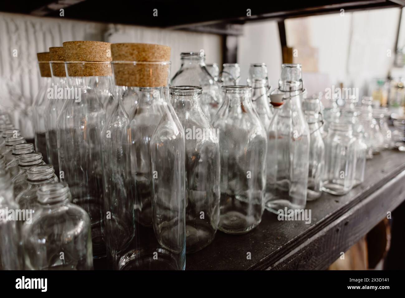 Une rangée soignée de bouteilles en verre transparent avec des bouchons en liège. Banque D'Images