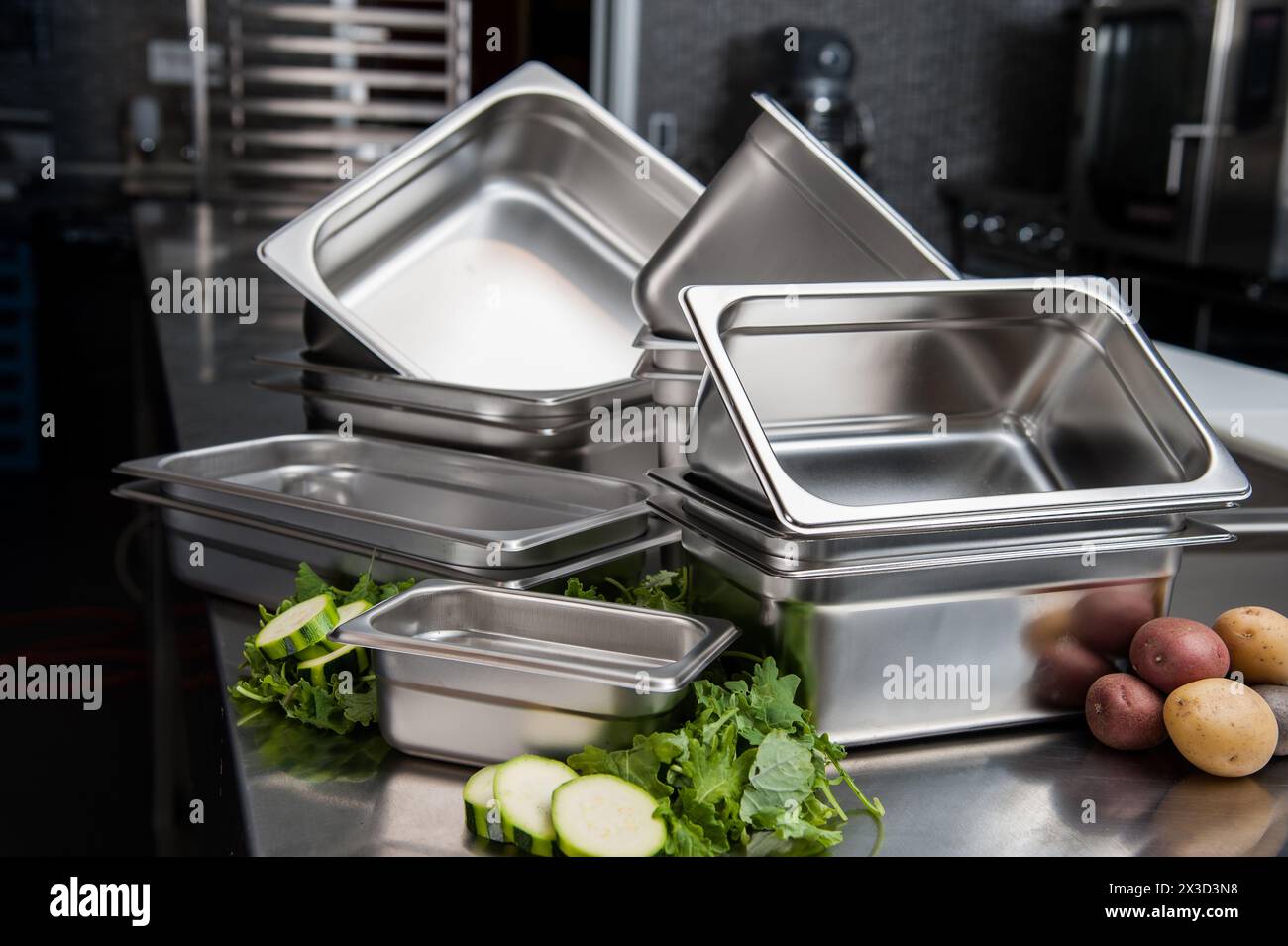 Casseroles en acier inoxydable empilées et légumes frais sur la table de préparation Banque D'Images