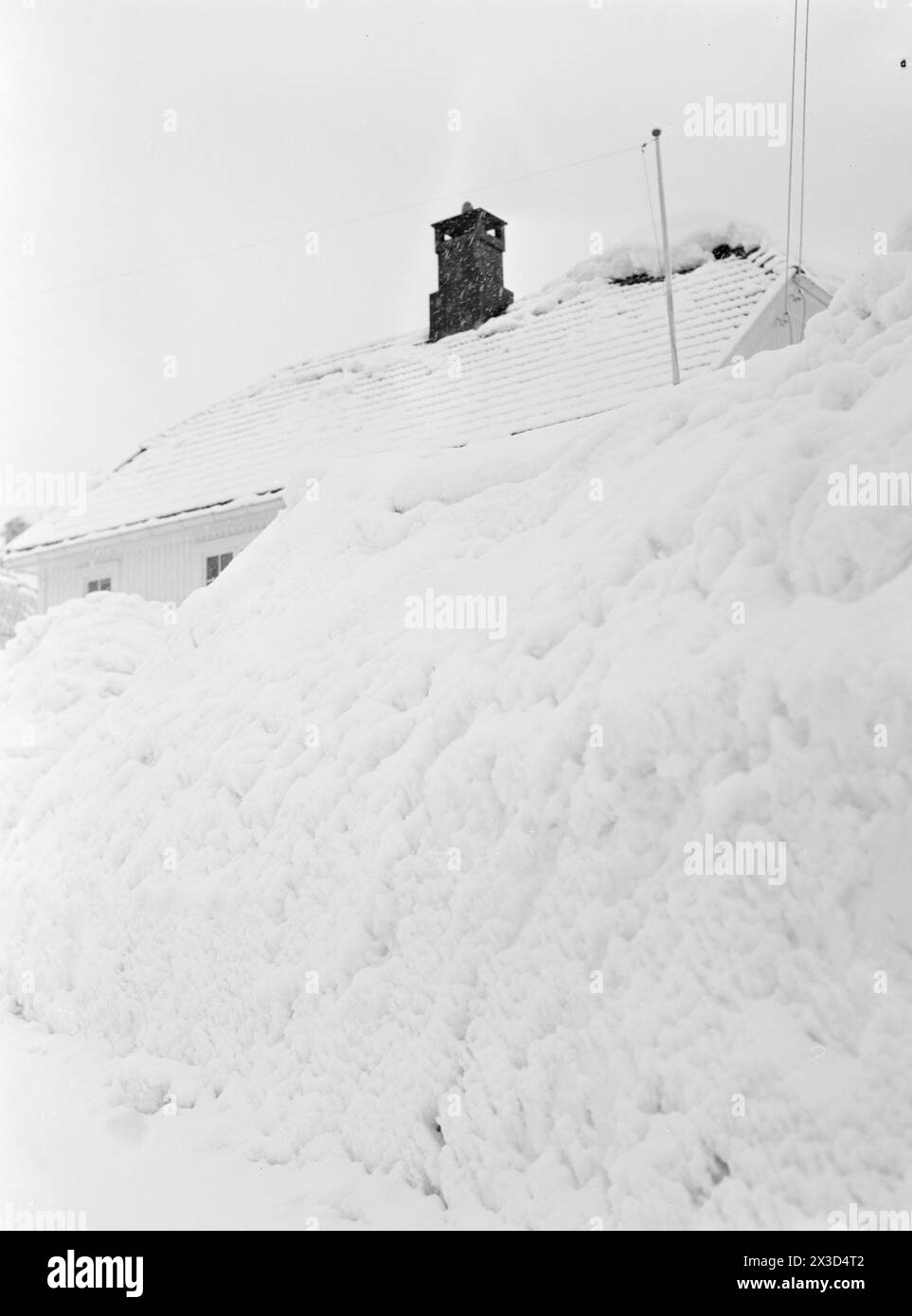 Réel 05- 1951 : le sud de la Norvège est couvert de neige. Quatre-cinq mètres de haut des bords de charrue le long des routes, la neige est si haute que vous pouvez facilement sortir du deuxième étage et les gens doivent constamment grimper sur les toits pour dégager la neige de là.photo : Arne Kjus / Aktuell / NTB ***la photo n'est pas traitée par image *** le texte de cette image est traduit automatiquement Banque D'Images