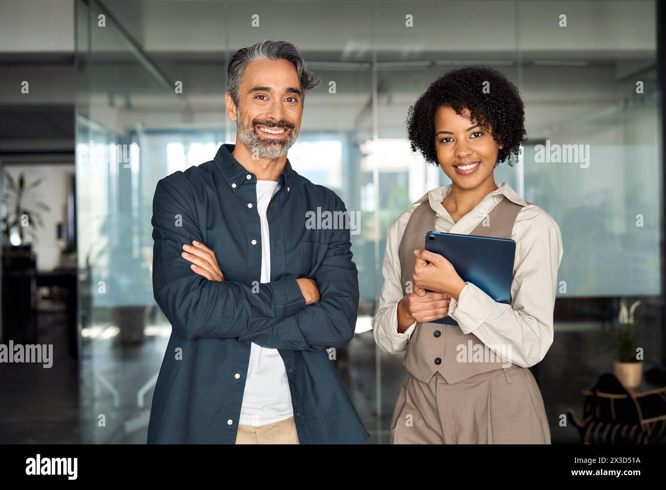 Deux partenaires commerciaux divers debout dans le bureau regardant la caméra, portrait. Banque D'Images