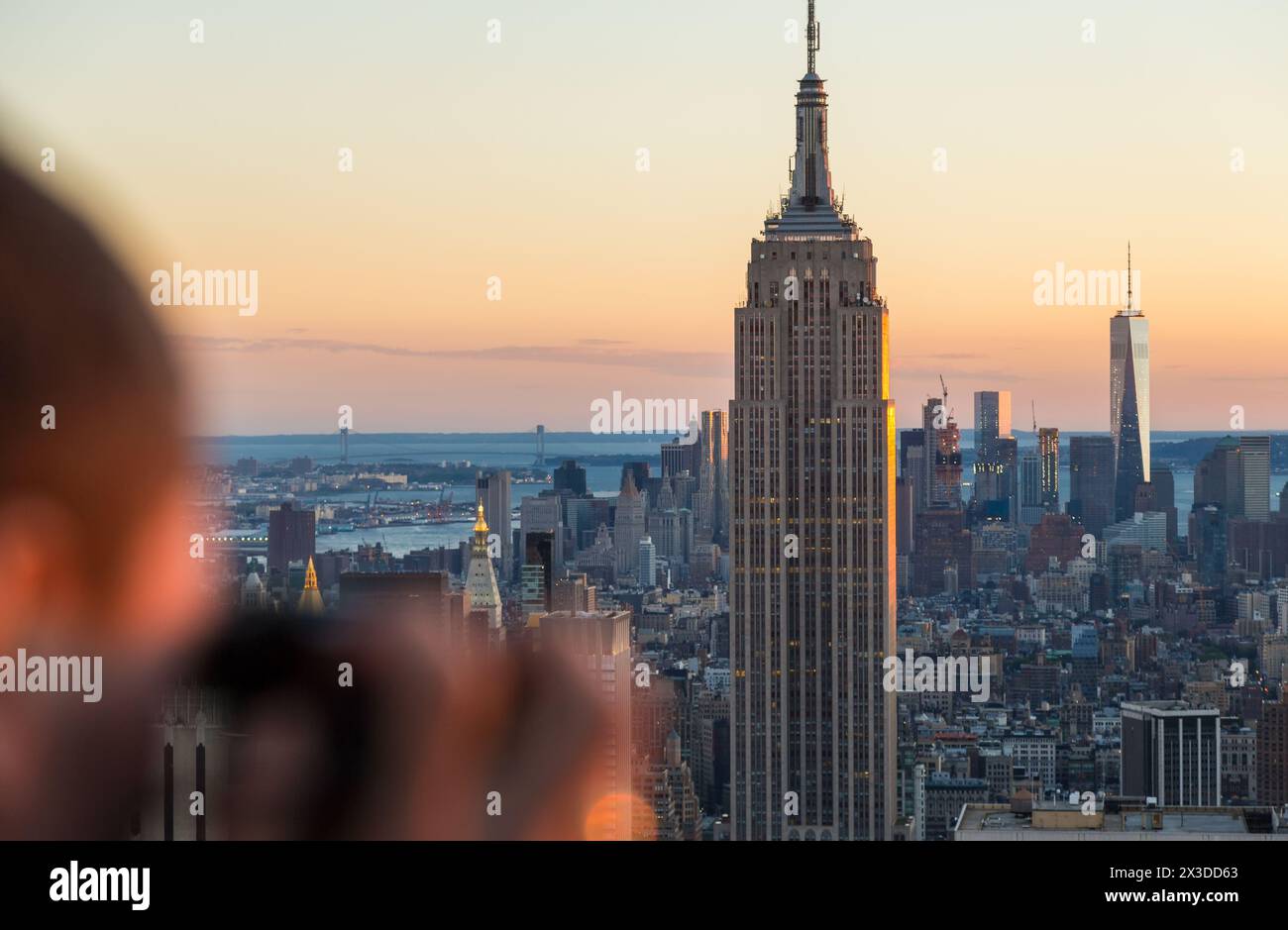 Homme avec appareil photo photographiant la vue sur l'Empire State Building et la ligne d'horizon, Manhattan, New York, États-Unis Banque D'Images