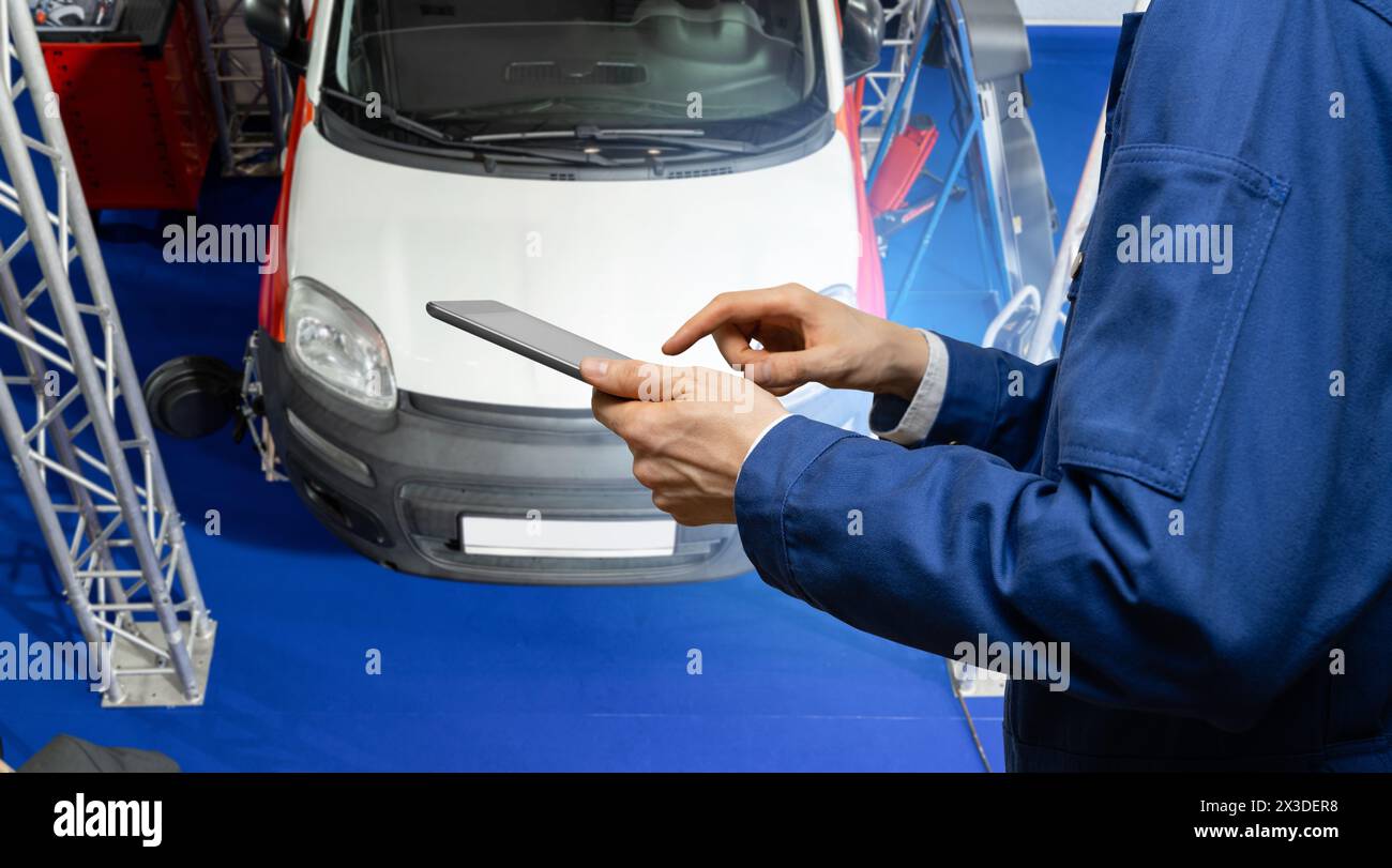 Technicien de service avec tablette numérique sur le fond de la voiture dans le service de voiture Banque D'Images