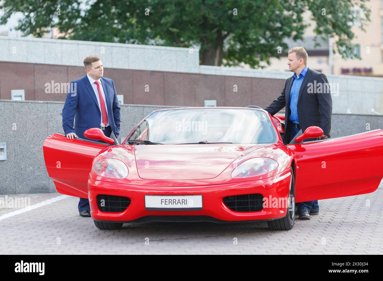 MOSCOU, RUSSIE - 22 juin 2016 : deux jeunes hommes d'affaires (avec des autorisations de modèles) vont prendre le volant de supercar de luxe rouge Ferrari Banque D'Images