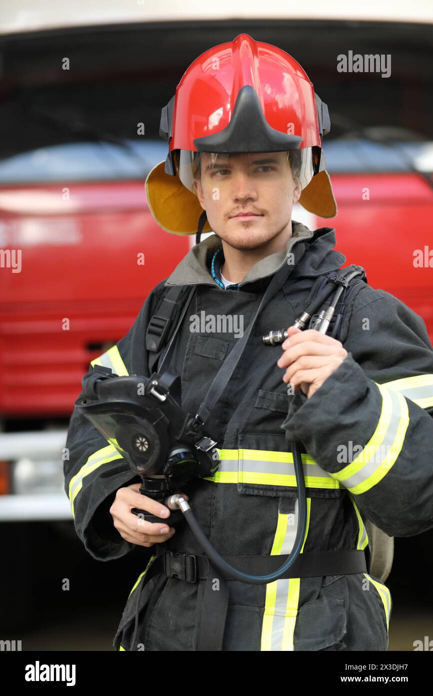 Portrait d'un pompier portant des aiguillages de Fire Fighter et un casque rouge. Banque D'Images