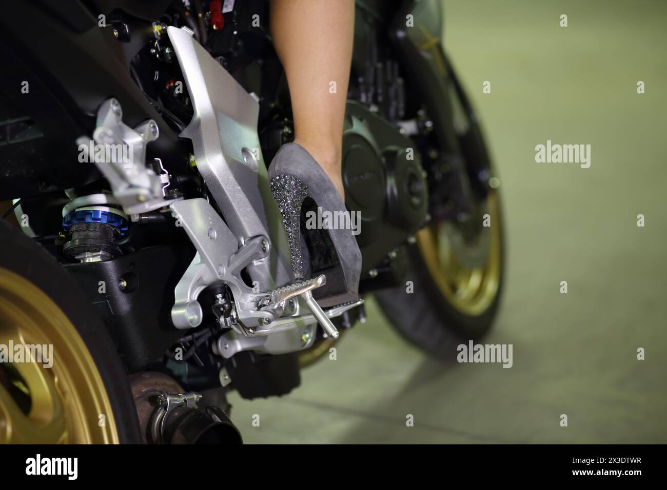 Vue rapprochée de la femme avec des chaussures grises à talons hauts et vélo noir. Banque D'Images