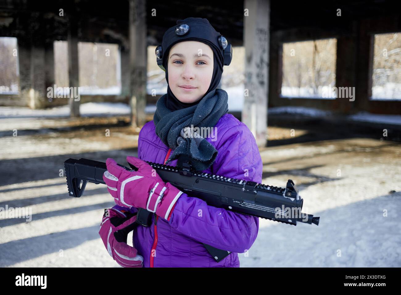 Adolescente avec pistolet de jeu en plein air le jour d'hiver. Banque D'Images