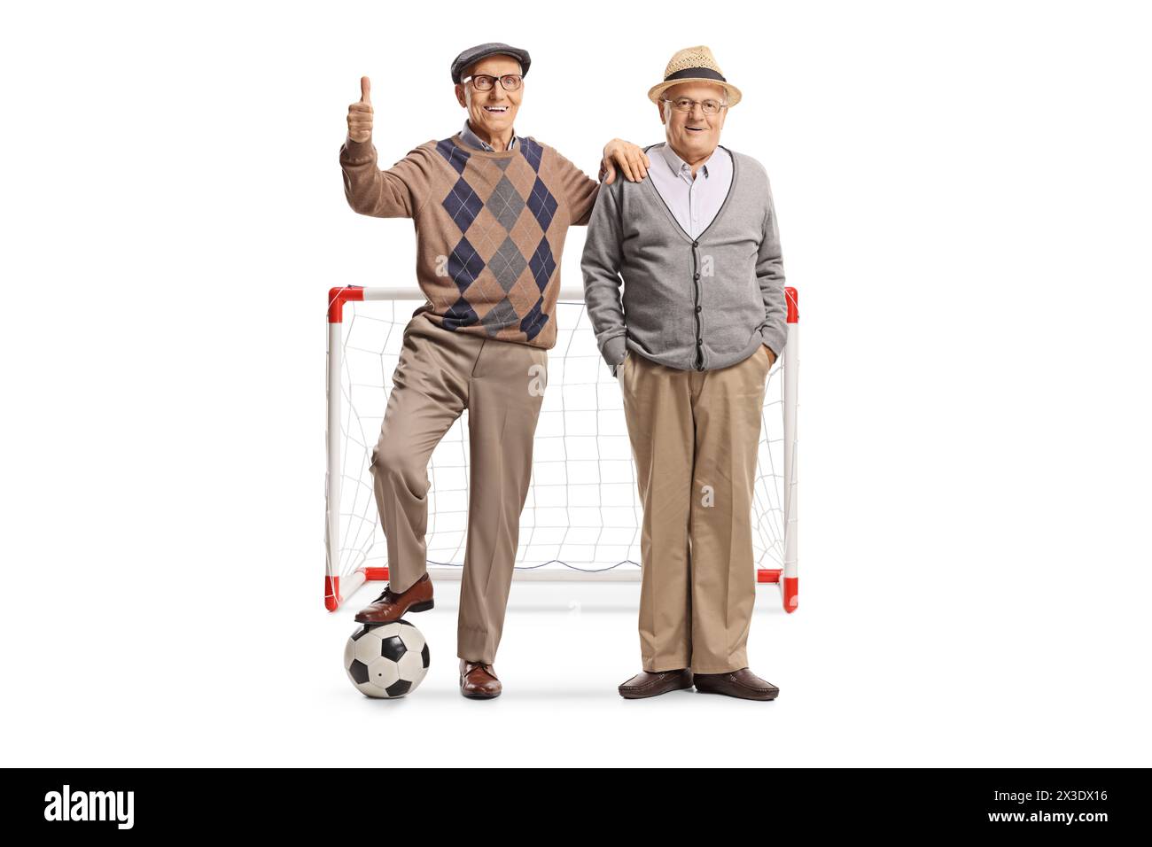 Hommes âgés debout avec un ballon de football devant un but et gestuelle pouces vers le haut isolés sur fond blanc Banque D'Images