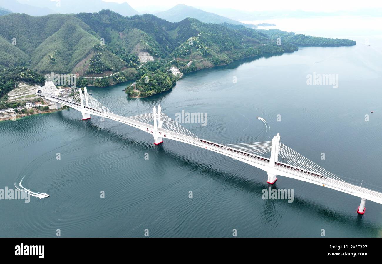 Hefei. 26 avril 2024. Une photo de drone aérien montre des trains circulant sur le grand pont de Taipinghu le long du chemin de fer Chizhou-Huangshan dans la province d'Anhui, dans l'est de la Chine, le 26 avril 2024. Le chemin de fer Chizhou-Huangshan, reliant la ville de Chizhou et la ville de Huangshan, dans la province d'Anhui, dans l'est de la Chine, a commencé à fonctionner vendredi. Il s'agit d'une route touristique reliant la montagne Jiuhua, la montagne Huangshan, le lac Taiping et d'autres attractions touristiques, ce qui est d'une grande importance pour la promotion du développement économique et social le long de la route. Crédit : Gu Shaoyuan/Xinhua/Alamy Live News Banque D'Images