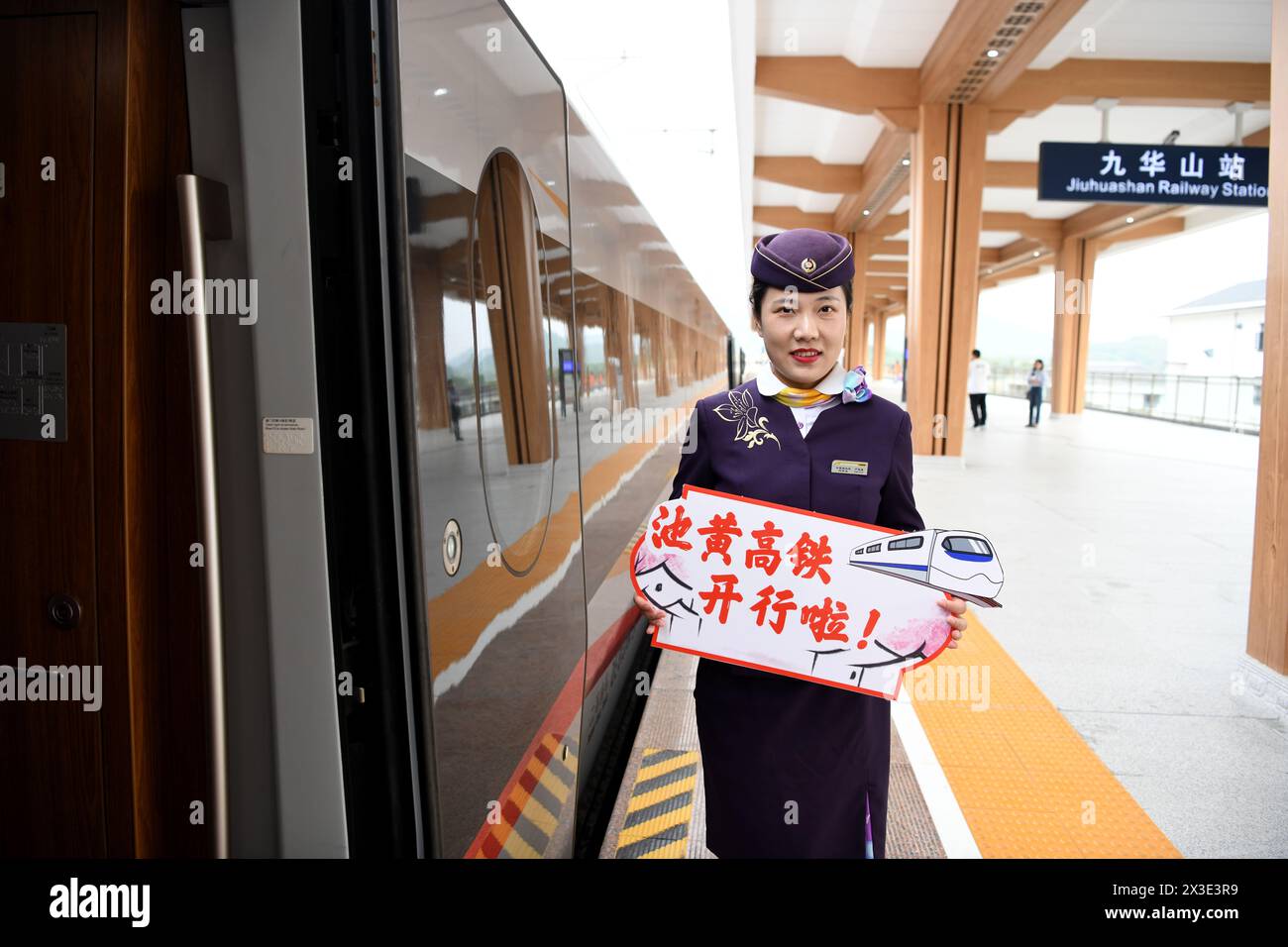 Hefei. 26 avril 2024. Un membre du personnel invite les passagers à monter à bord d'un train à la gare de Jiuhuashan le long de la ligne Chizhou-Huangshan dans la province d'Anhui, dans l'est de la Chine, le 26 avril 2024. Le chemin de fer Chizhou-Huangshan, reliant la ville de Chizhou et la ville de Huangshan, dans la province d'Anhui, dans l'est de la Chine, a commencé à fonctionner vendredi. Il s'agit d'une route touristique reliant la montagne Jiuhua, la montagne Huangshan, le lac Taiping et d'autres attractions touristiques, ce qui est d'une grande importance pour la promotion du développement économique et social le long de la route. Crédit : Liu Junxi/Xinhua/Alamy Live News Banque D'Images