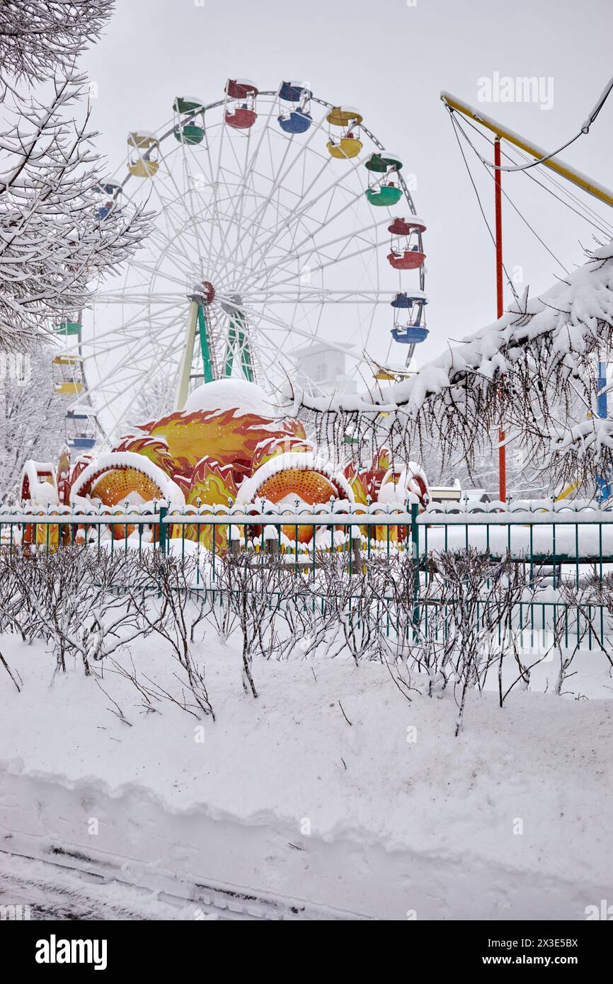Grande roue dans un parc d'hiver enneigé. Banque D'Images