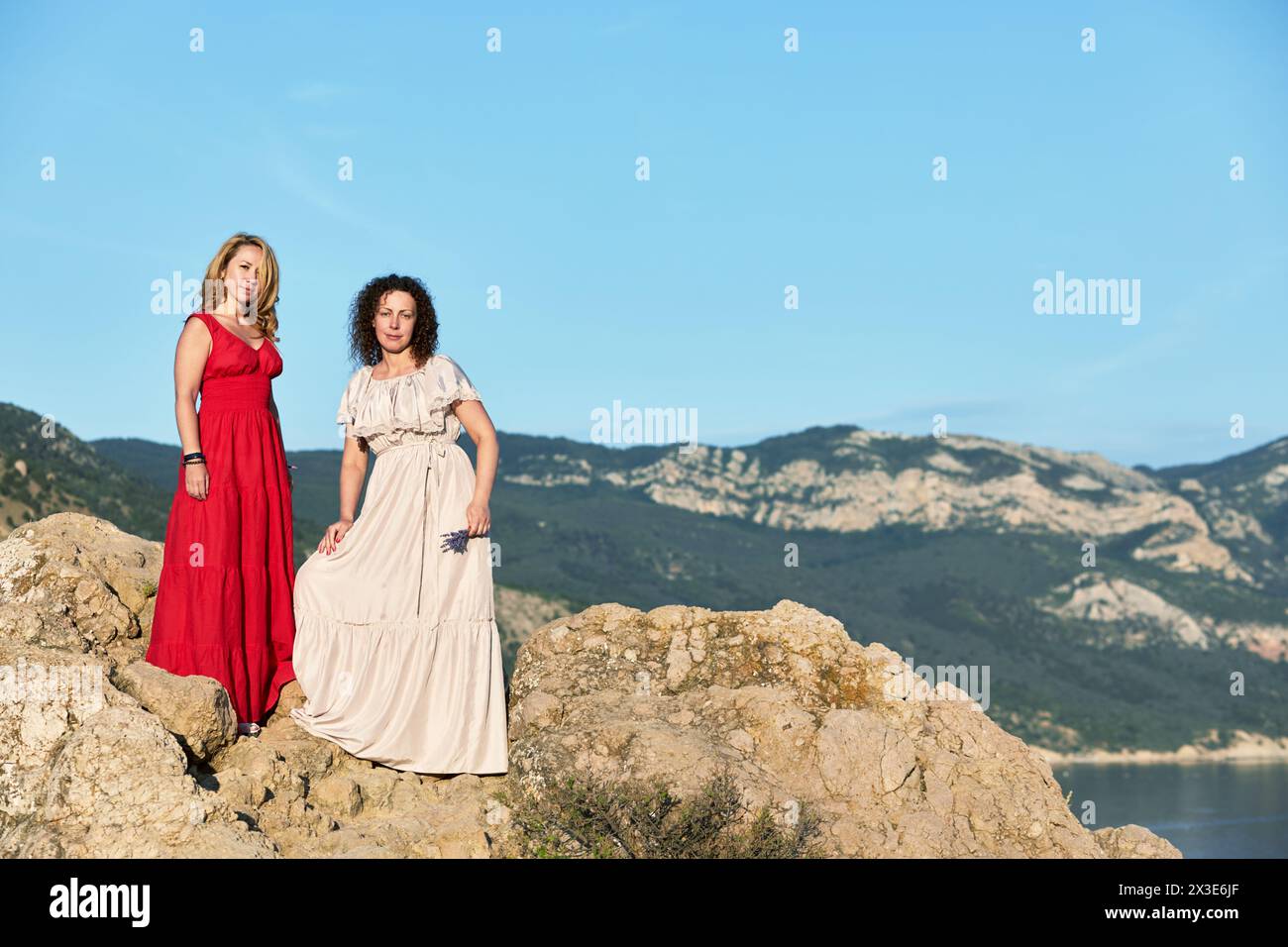 Deux femmes contre le ciel, les collines et la mer. Banque D'Images