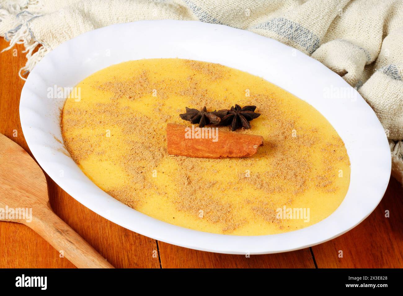 Curau, crème de maïs sucré et dessert typique de la cuisine brésilienne, placé dans un bol en céramique sur une table en bois. Gros plan Banque D'Images