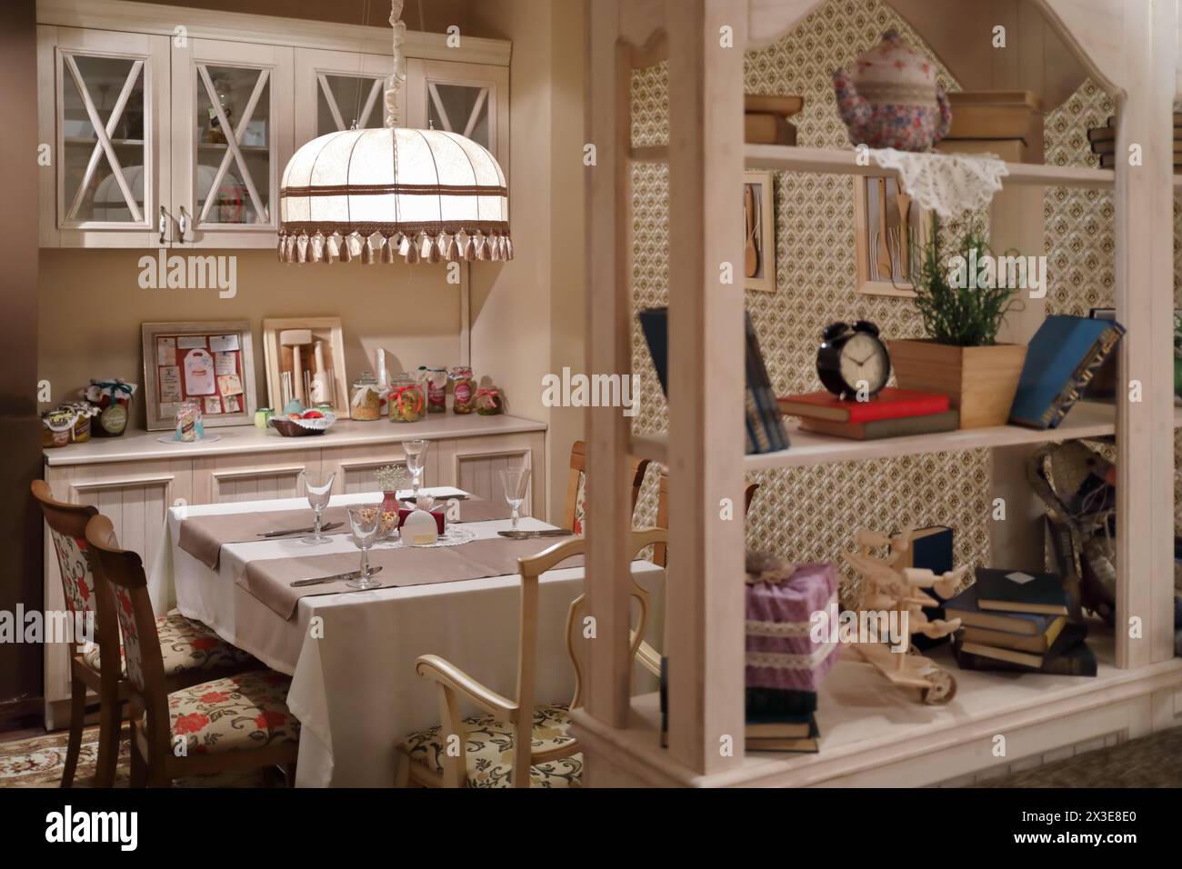 Service sur table avec nappe dans un restaurant vide de style maison avec abat-jour, étagères Banque D'Images
