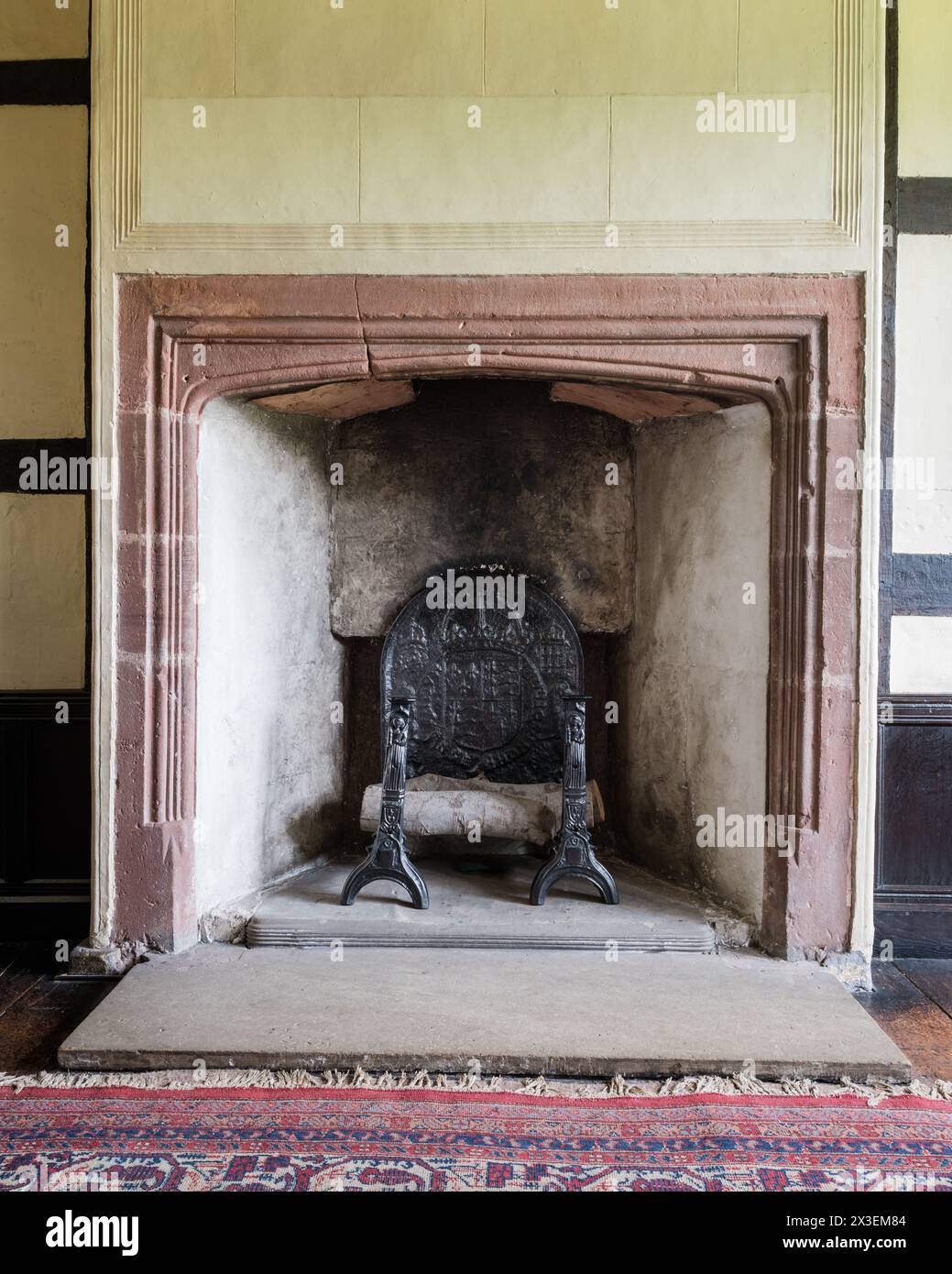 Cheminée et grille dans Speke Hall, Grade I classé National Trust Tudor Manor House, Liverpool, Angleterre, Royaume-Uni. Banque D'Images
