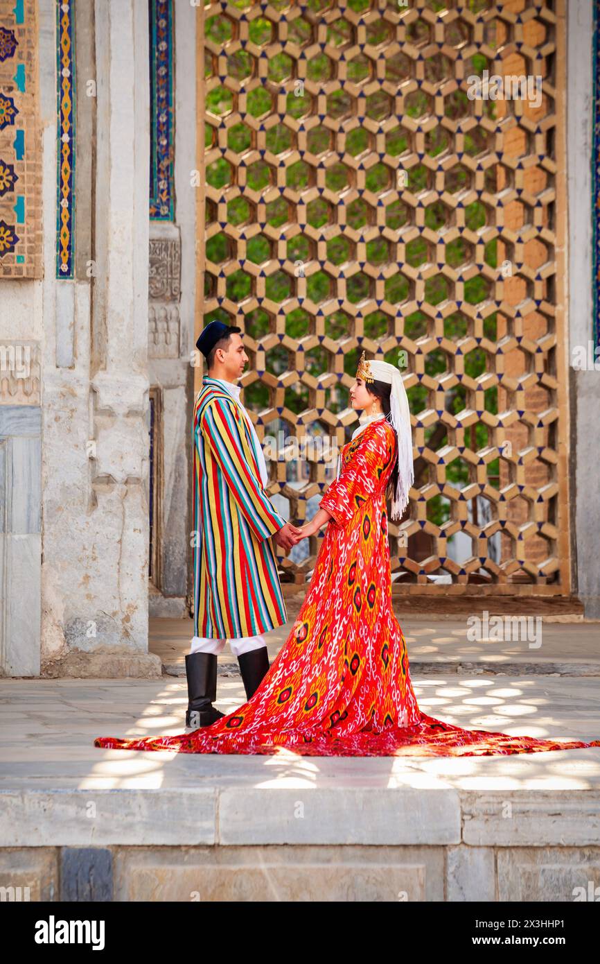 Samarkand, Ouzbékistan - 18 avril 2021 : mariée et marié dans des robes ouzbèkes traditionnelles à la ville antique du Registan, Samarkand ville en Ouzbékistan Banque D'Images