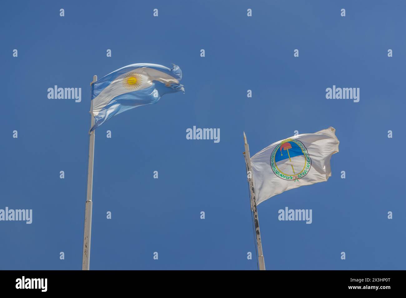 Drapeaux de l'Argentine et Jujuy volant au-dessus d'un ciel bleu. Banque D'Images
