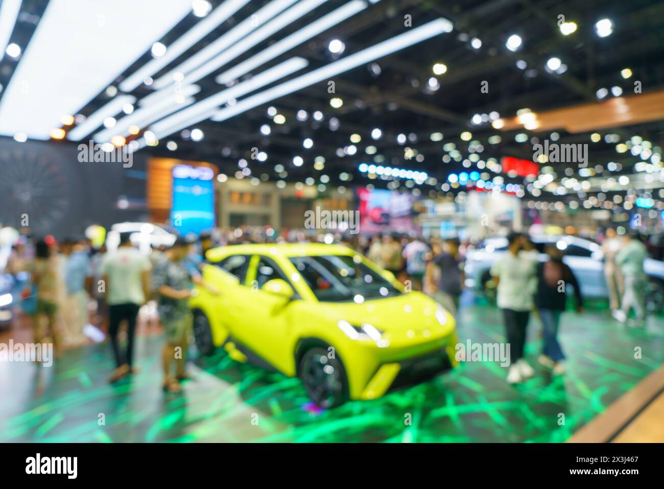 Un showroom de voiture moderne. Le flou met en évidence les lignes épurées et les couleurs vibrantes des véhicules exposés, ce qui en fait un arrière-plan idéal pour les autom Banque D'Images