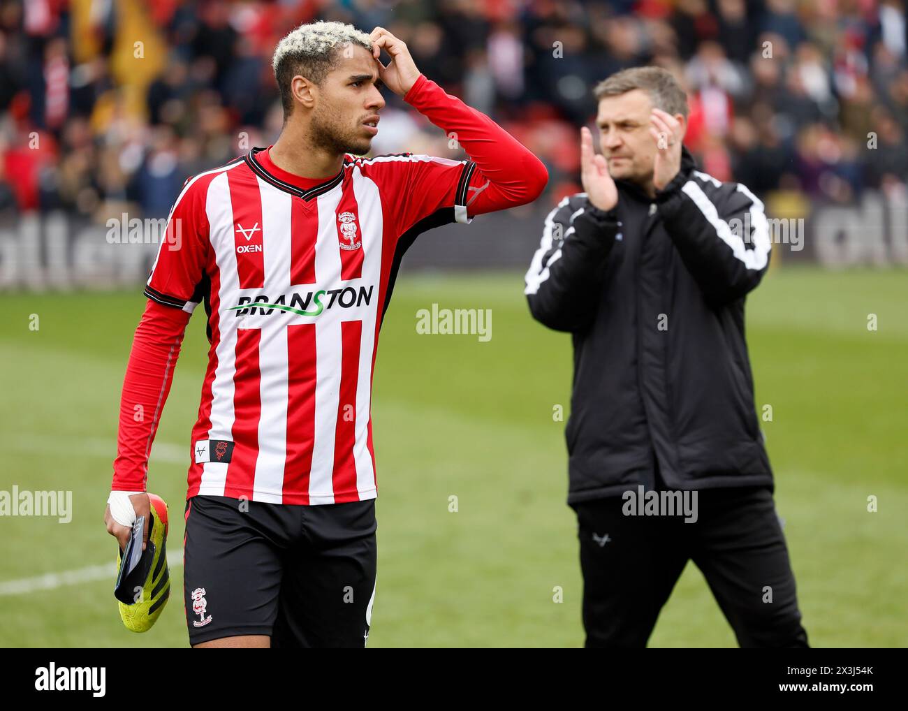 Ethan Erhahon de Lincoln City et Michael Skubala, manager de Lincoln City, après le match de Sky Bet League One au LNER Stadium de Lincoln. Date de la photo : samedi 27 avril 2024. Banque D'Images