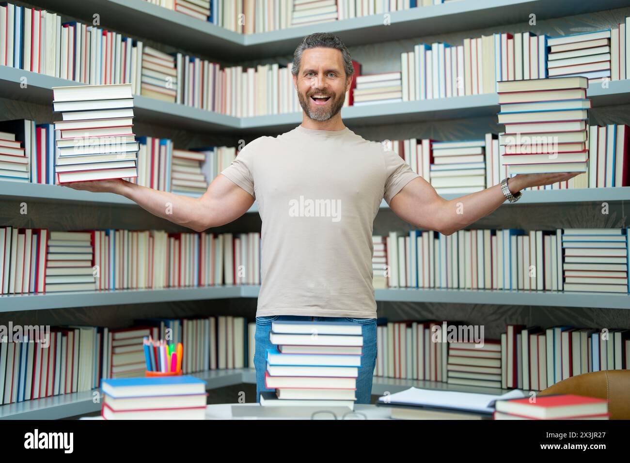 Drôle d'enseignant de tenir beaucoup de livres. Professeur fou avec des livres. Enseignant enthousiaste dans la bibliothèque de livres de l'école. Examen universitaire. Étudier enseigner à l'université. Éducateur Banque D'Images