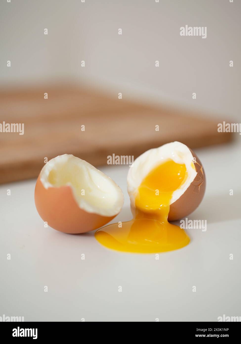 Gros plan d'un œuf à moitié cuit craqué Banque D'Images