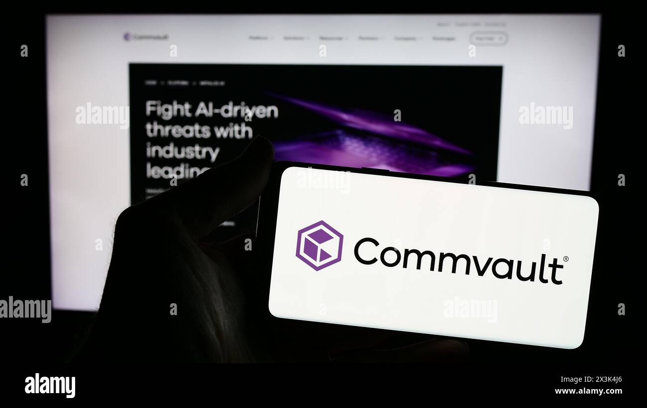 Personne tenant un smartphone avec le logo de la société américaine de logiciels Commvault Systems Inc devant le site Web. Concentrez-vous sur l'affichage du téléphone. Banque D'Images