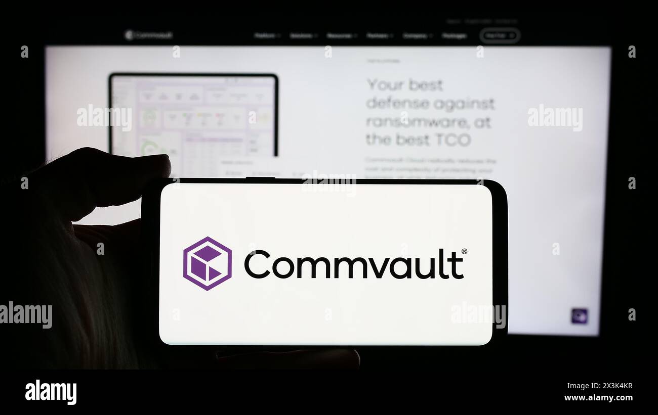 Personne tenant le téléphone portable avec le logo de la société américaine de logiciels Commvault Systems Inc devant la page Web de l'entreprise. Concentrez-vous sur l'affichage du téléphone. Banque D'Images