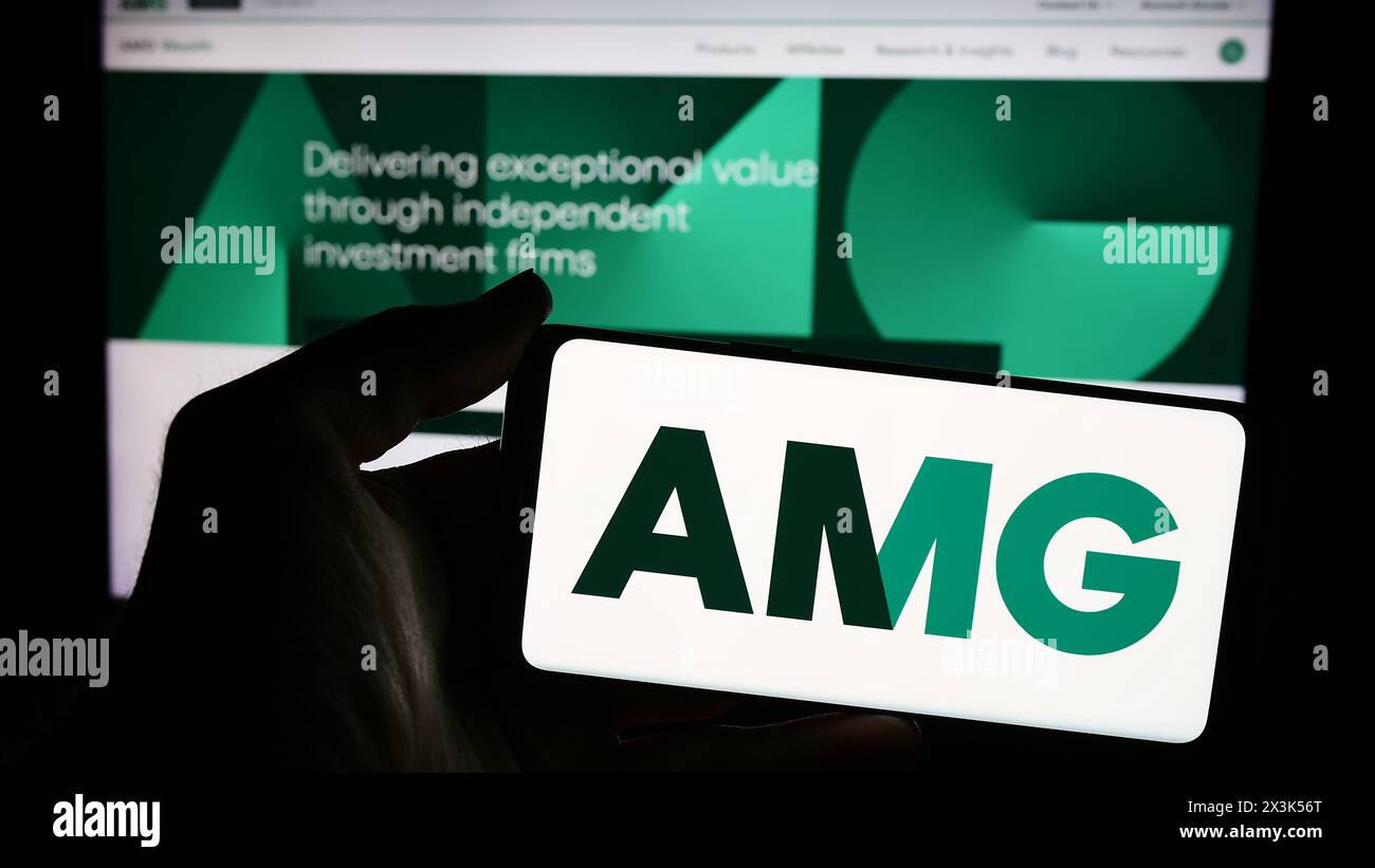 Personne tenant un smartphone avec le logo de la société américaine Affiliated Managers Group Inc (AMG) devant le site Web. Concentrez-vous sur l'affichage du téléphone. Banque D'Images