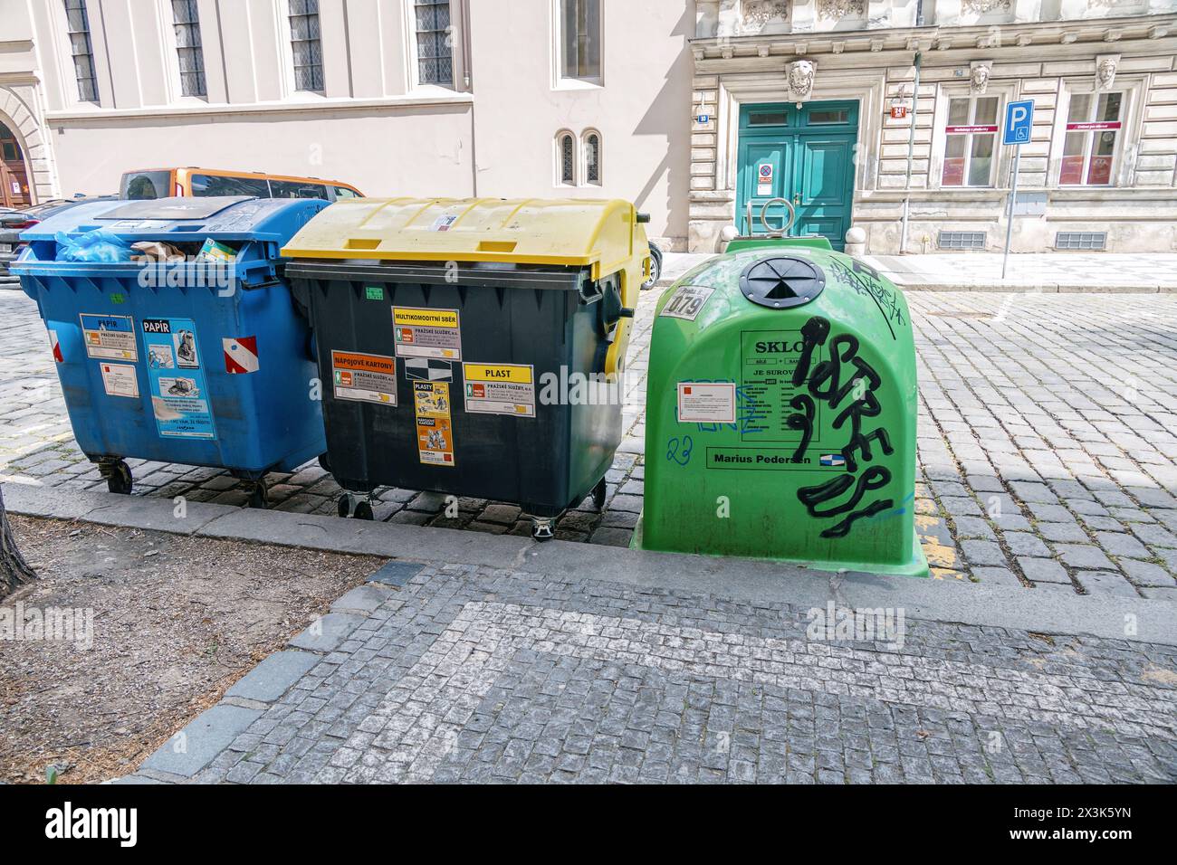 Bacs de recyclage pour le papier, le plastique et le verre, marqués de graffitis, dans une rue du quartier Karlin de Prague. Banque D'Images
