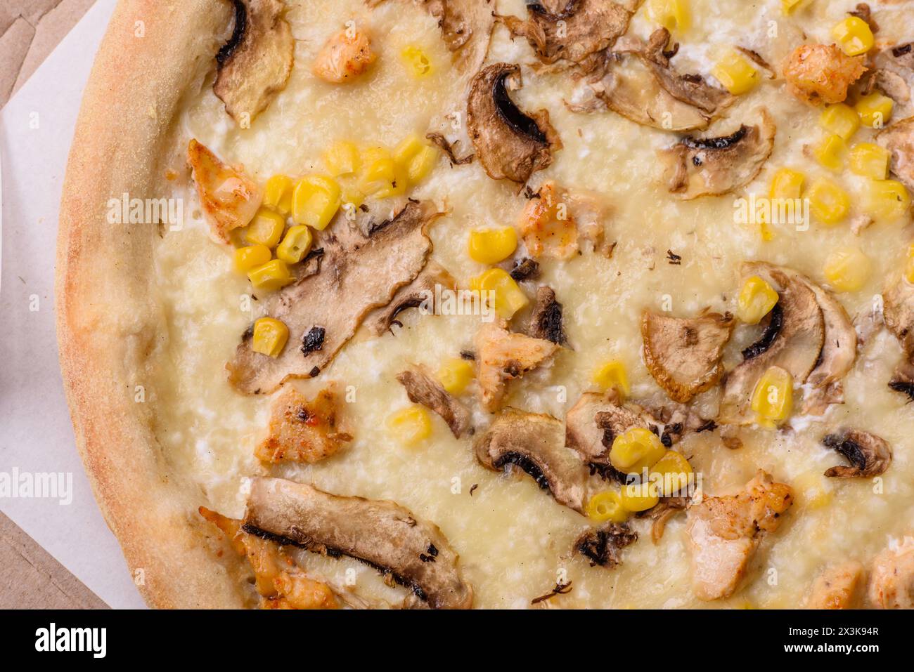 Délicieuse pizza avec du maïs, du fromage, des tomates et des champignons, du sel, des épices et des herbes sur un fond de béton foncé Banque D'Images