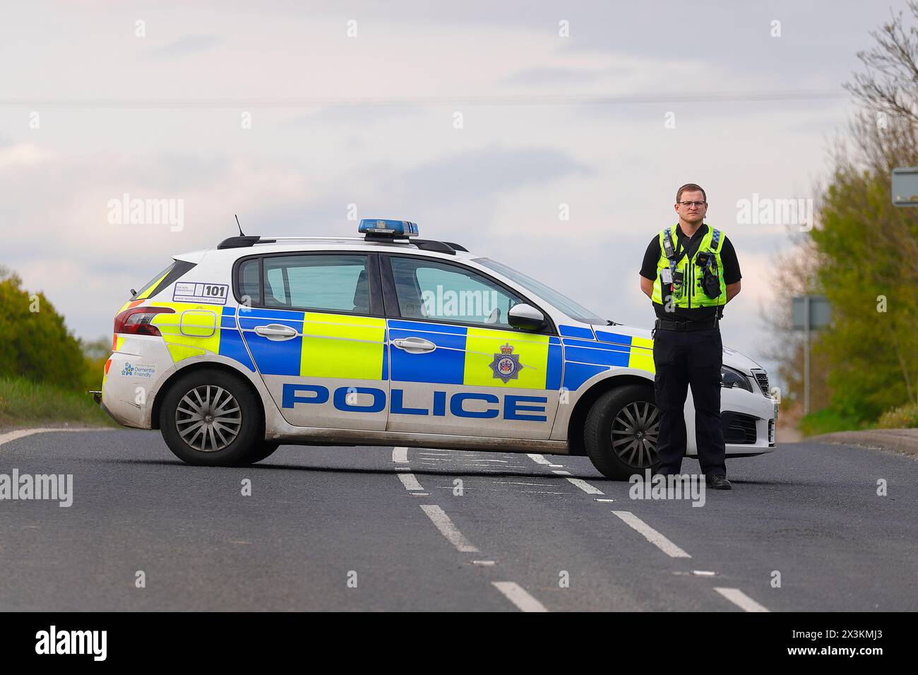 Un policier détourne la circulation d'un incident sur Wakefield Road à Swillington, Leeds, West Yorkshire, UK Banque D'Images