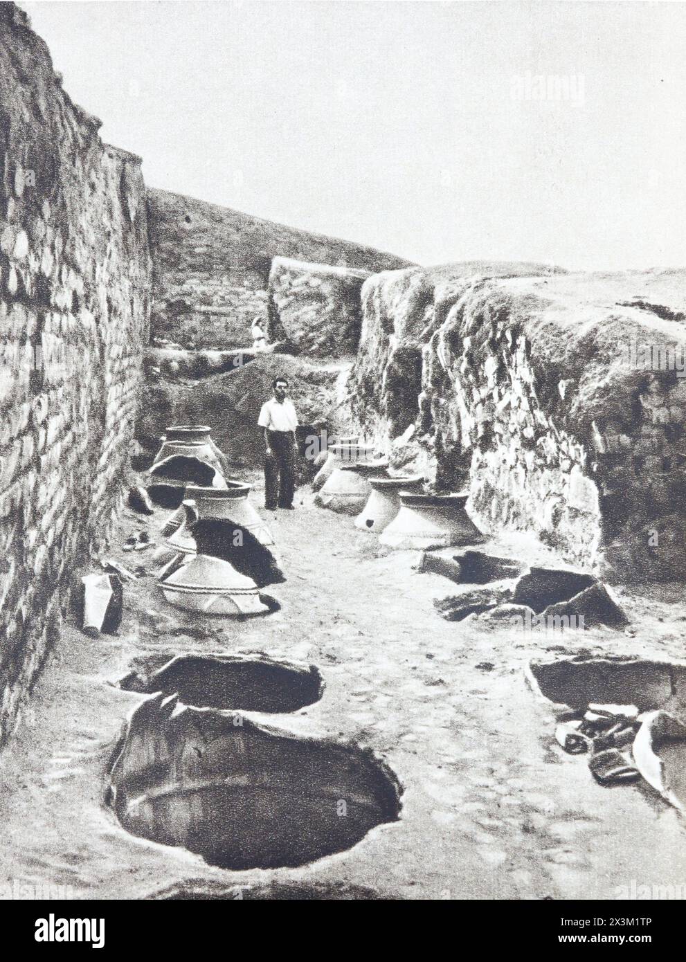 Un garde-manger avec des récipients pour stocker le vin et le grain creusé dans le sol dans le palais du roi Rusa II d'Urartu. Photographie du milieu du XXe siècle. Banque D'Images