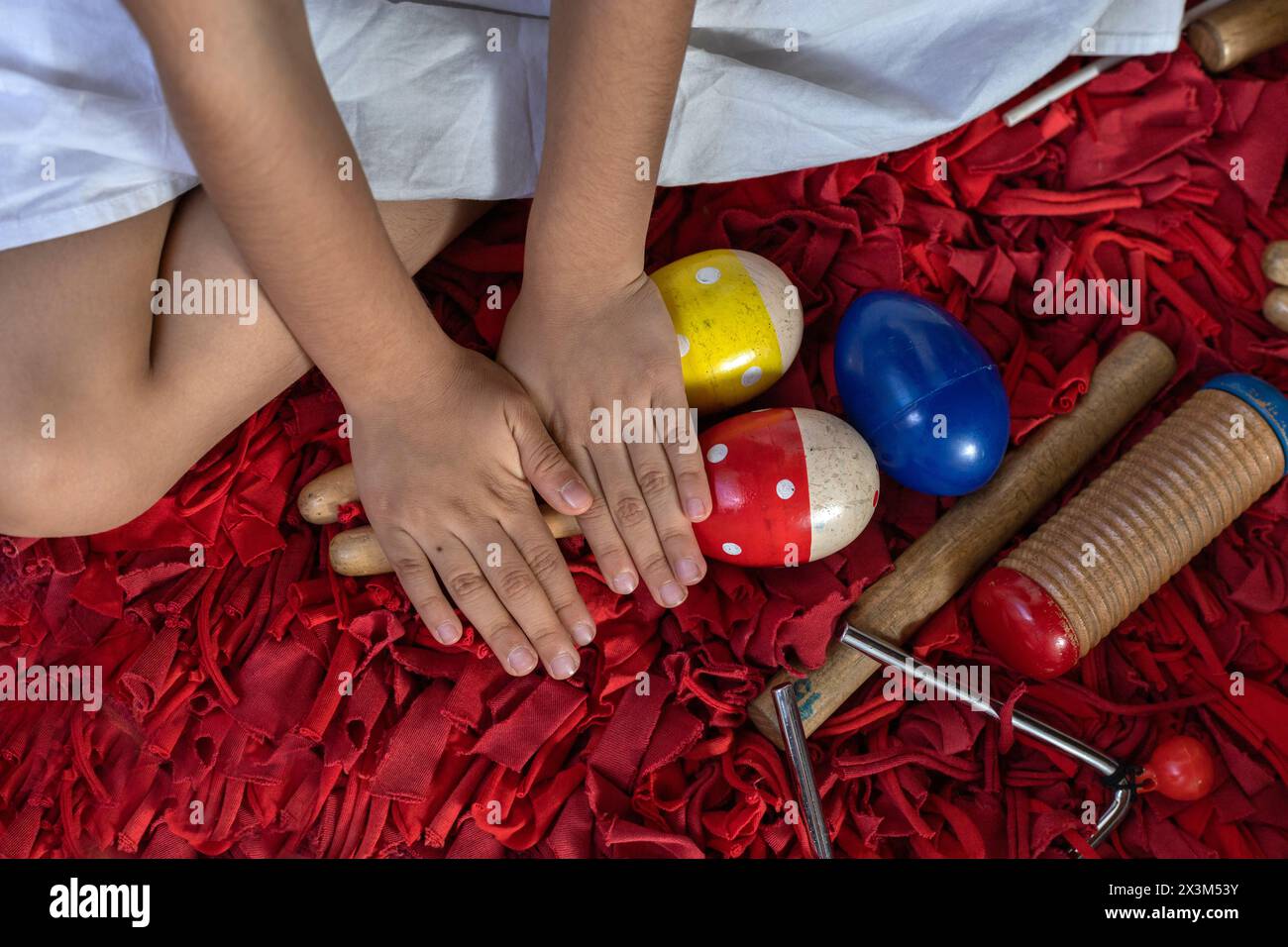 Mains de fille latino-américaine dans sa classe de musique avec ses instruments à percussion. Banque D'Images