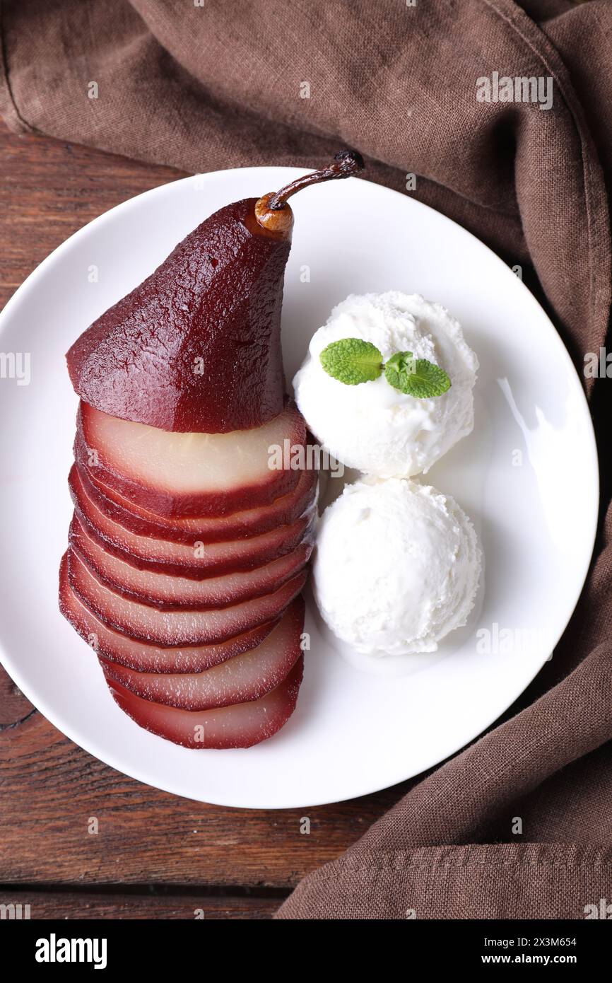 Savoureux vin rouge poché poire et crème glacée sur table en bois, vue de dessus Banque D'Images