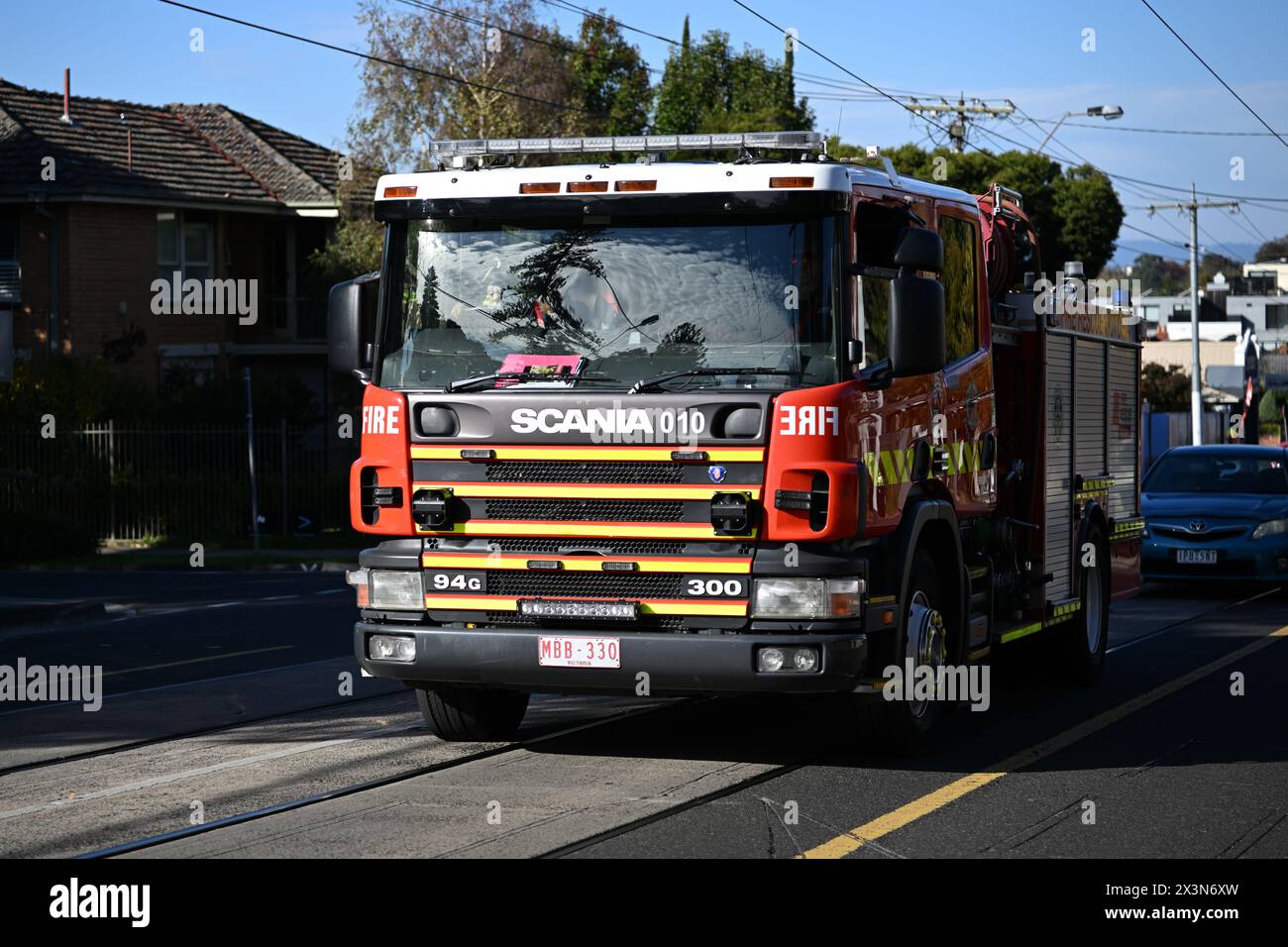 Vue de face d'un camion de pompiers rouge Scania 94G 300 exploité par Fire Rescue Victoria, ou FRV, dans une rue de la banlieue de Melbourne pendant une journée ensoleillée Banque D'Images