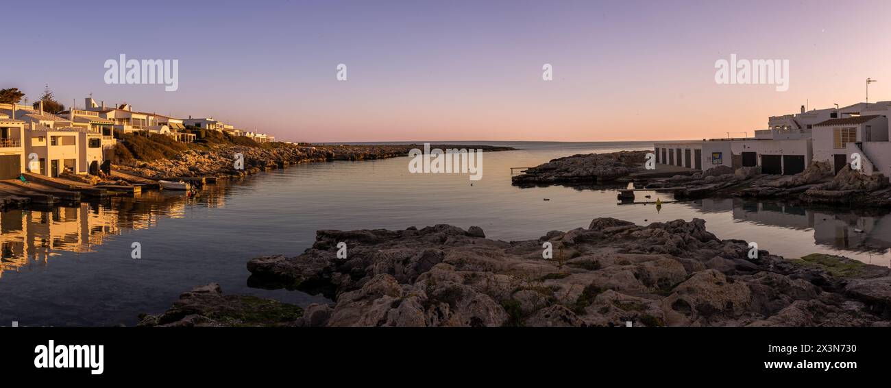 Fotografía panorámica de la cala de Biniancolla en la isla de Menorca, que ofrece un pintoresco paisaje de típicas casas blancas. España Banque D'Images