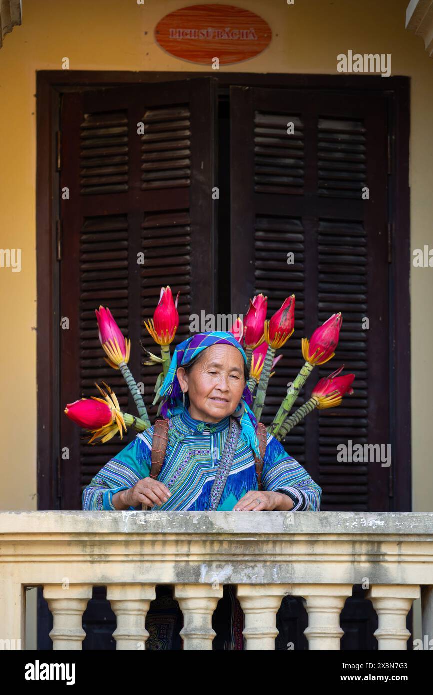 Femme hmong de fleurs portant un panier de fleurs dans le palais des rois Hmong (Vau Meo) à bac Ha, province de Lao Cai, Vietnam Banque D'Images