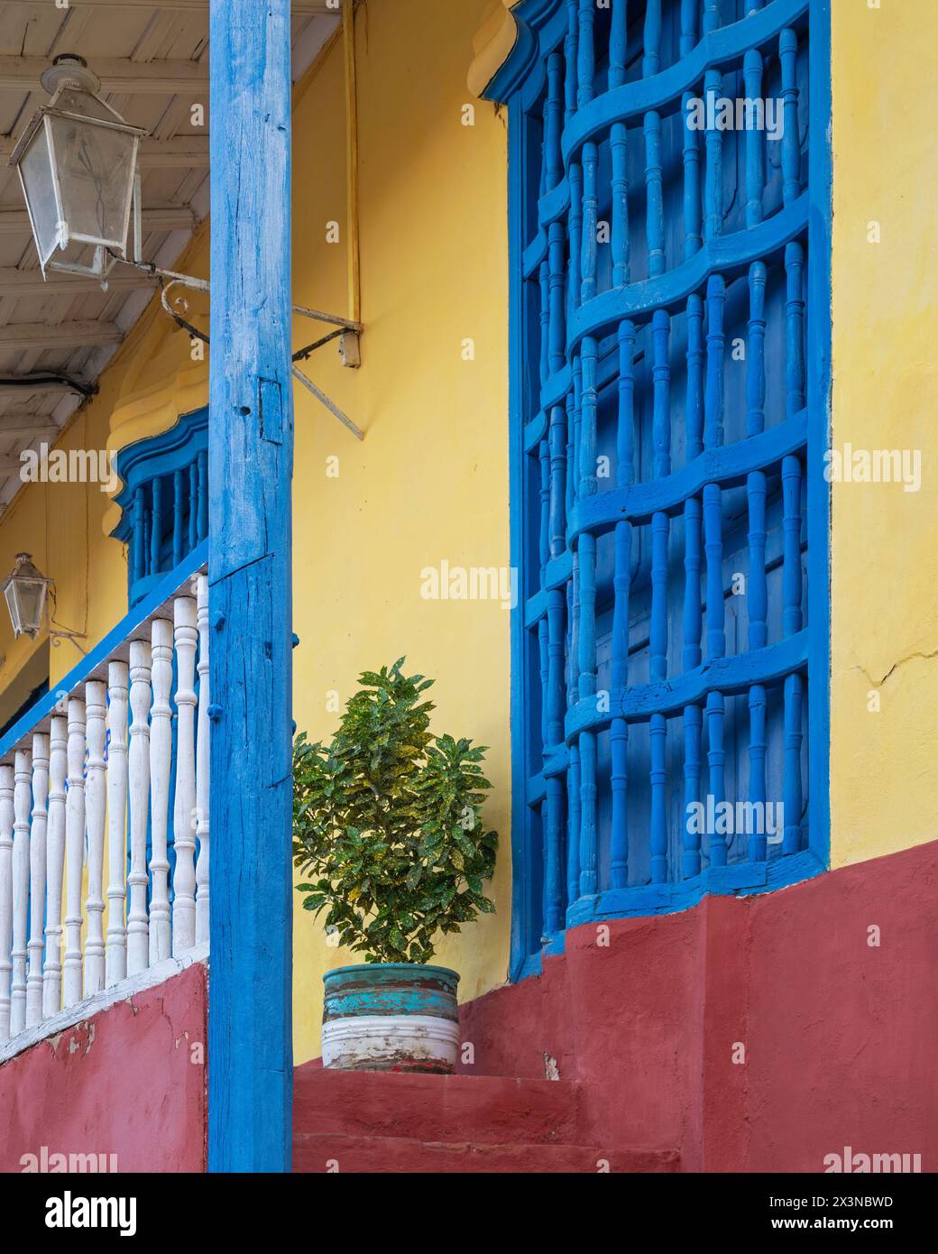 Murs peints de couleurs vives et grilles métalliques sur les fenêtres de maisons anciennes dans les ruelles de Trinidad, Cuba. Banque D'Images