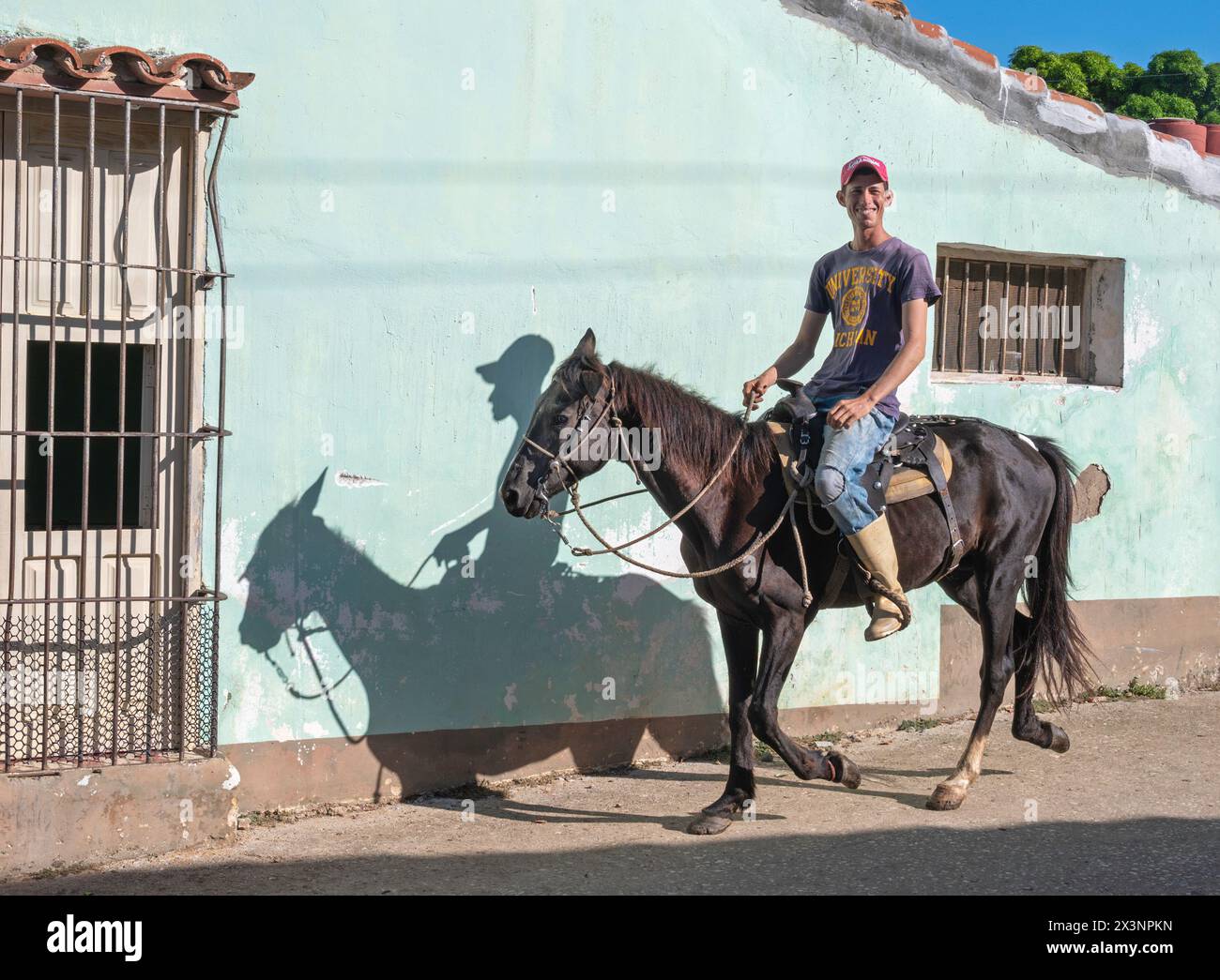 Un local qui monte son cheval dans les rues latérales de la vieille ville, Trinidad, Cuba Banque D'Images