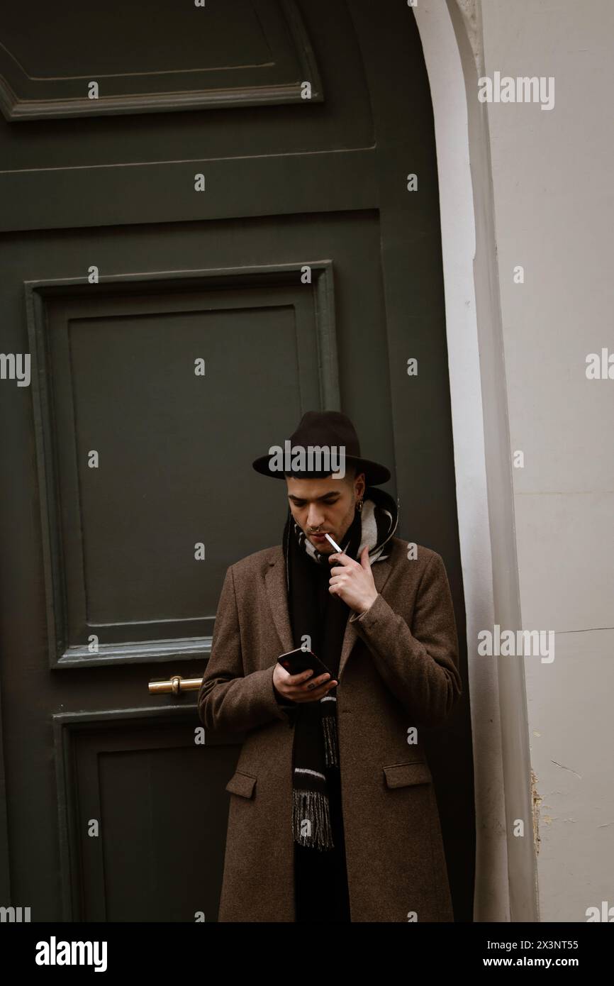 Homme au hasard debout devant une porte d'entrée verte à Paris-France. StreetStyle. Banque D'Images