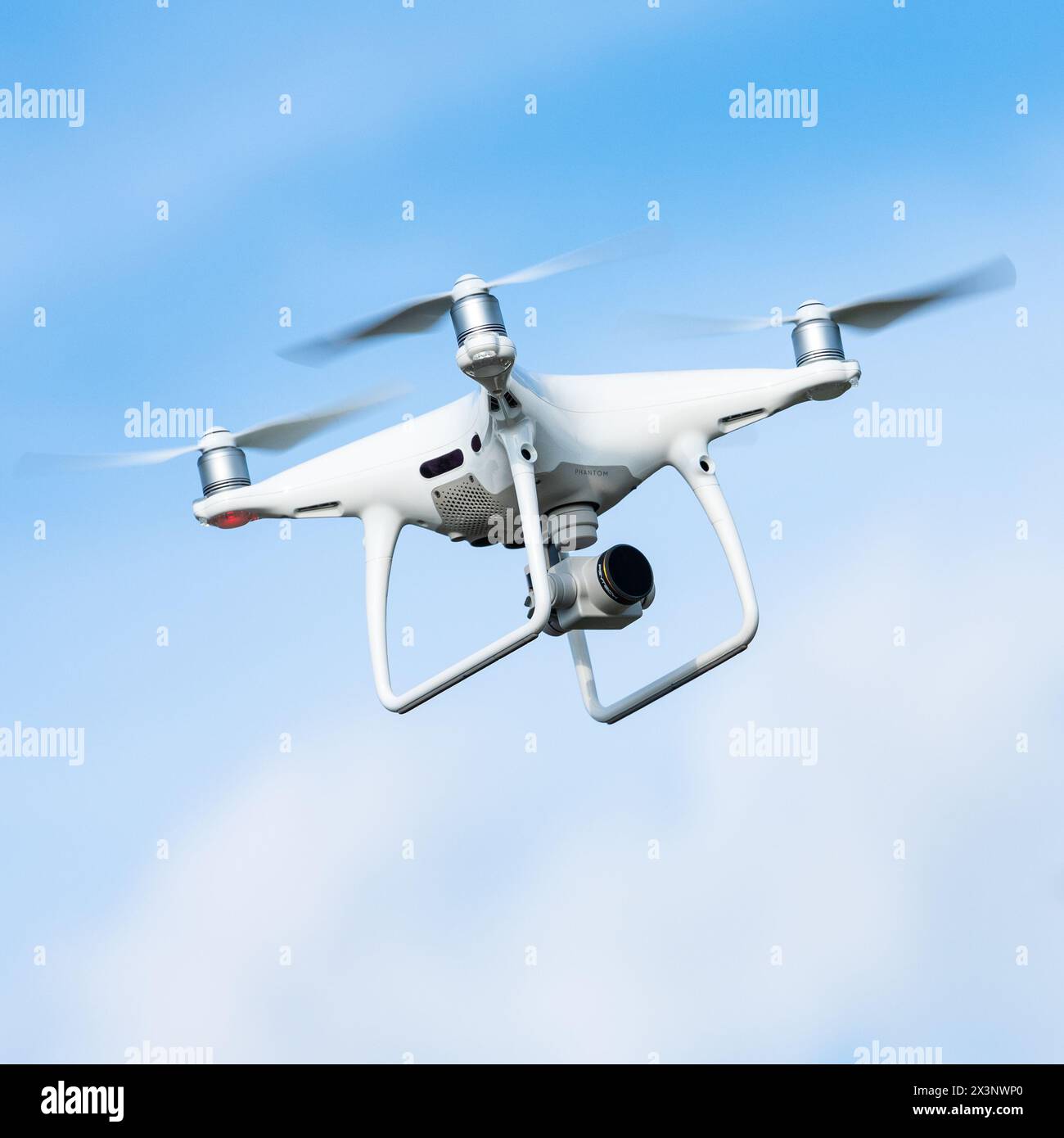 Véhicule aérien sans pilote drone drone quadrocopter ou quadrorotor DJI avec caméra en action dans le ciel et tourne la vidéo autour de lui de la vue d'oiseau dans le soleil Banque D'Images