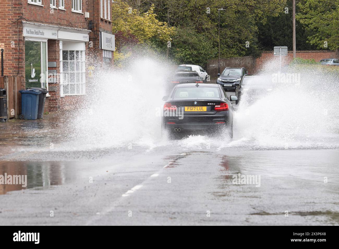 Chalfont St Giles, Buckinghamshire, Royaume-Uni. 28 avril 2024. Automobilistes conduisant dans les eaux de crue. Certaines parties du village de Chalfont St Giles dans le Buckinghamshire ont été inondées aujourd'hui après de fortes pluies nocturnes. Il y a des problèmes continus avec les inondations des eaux souterraines à travers les Chalfonts. Crédit : Maureen McLean/Alamy Live News Banque D'Images