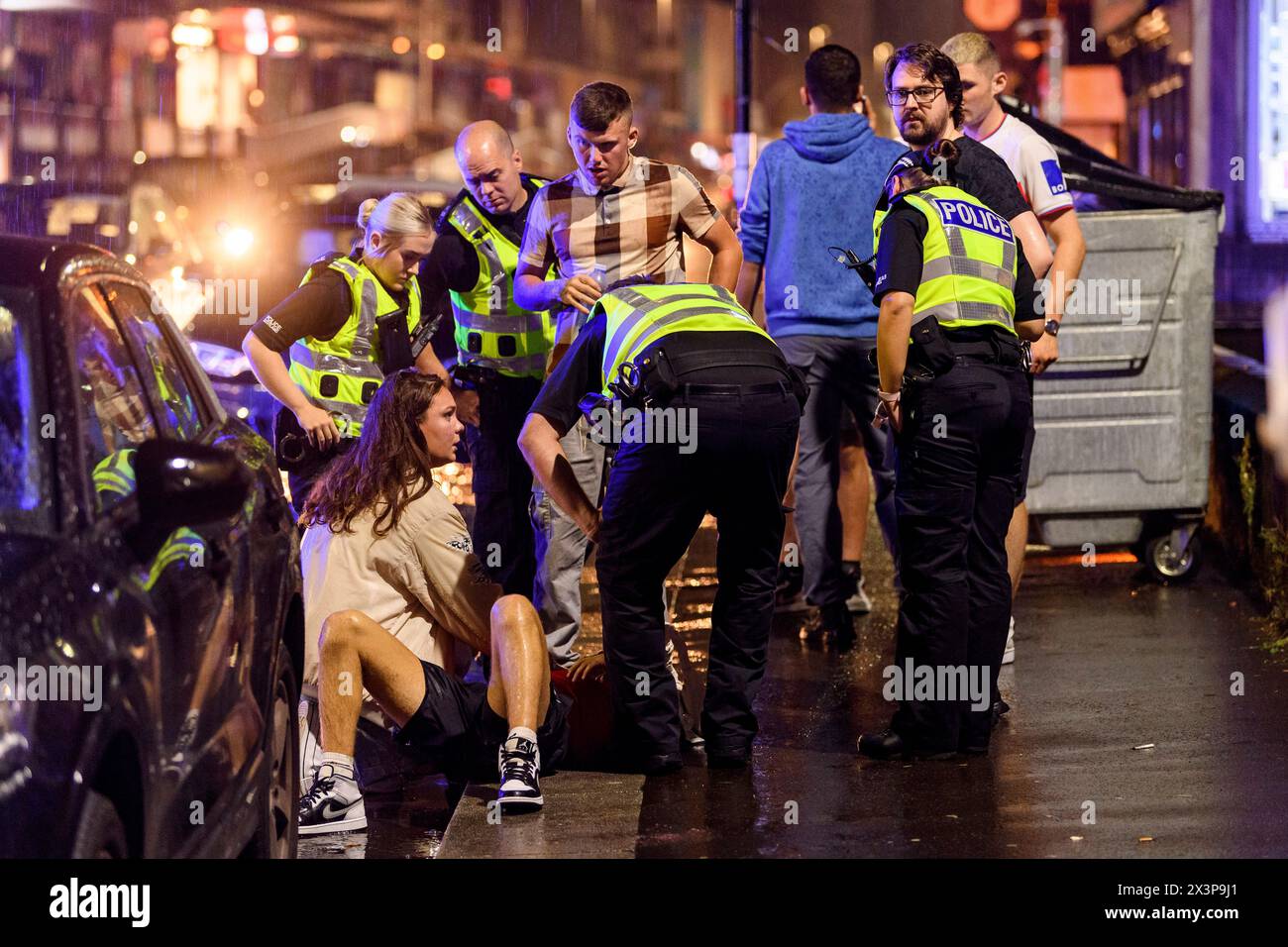 Les officiers de Police Scotland et les services d'urgence s'occupent des membres du public la nuit à Glasgow, Écosse, Royaume-Uni Banque D'Images