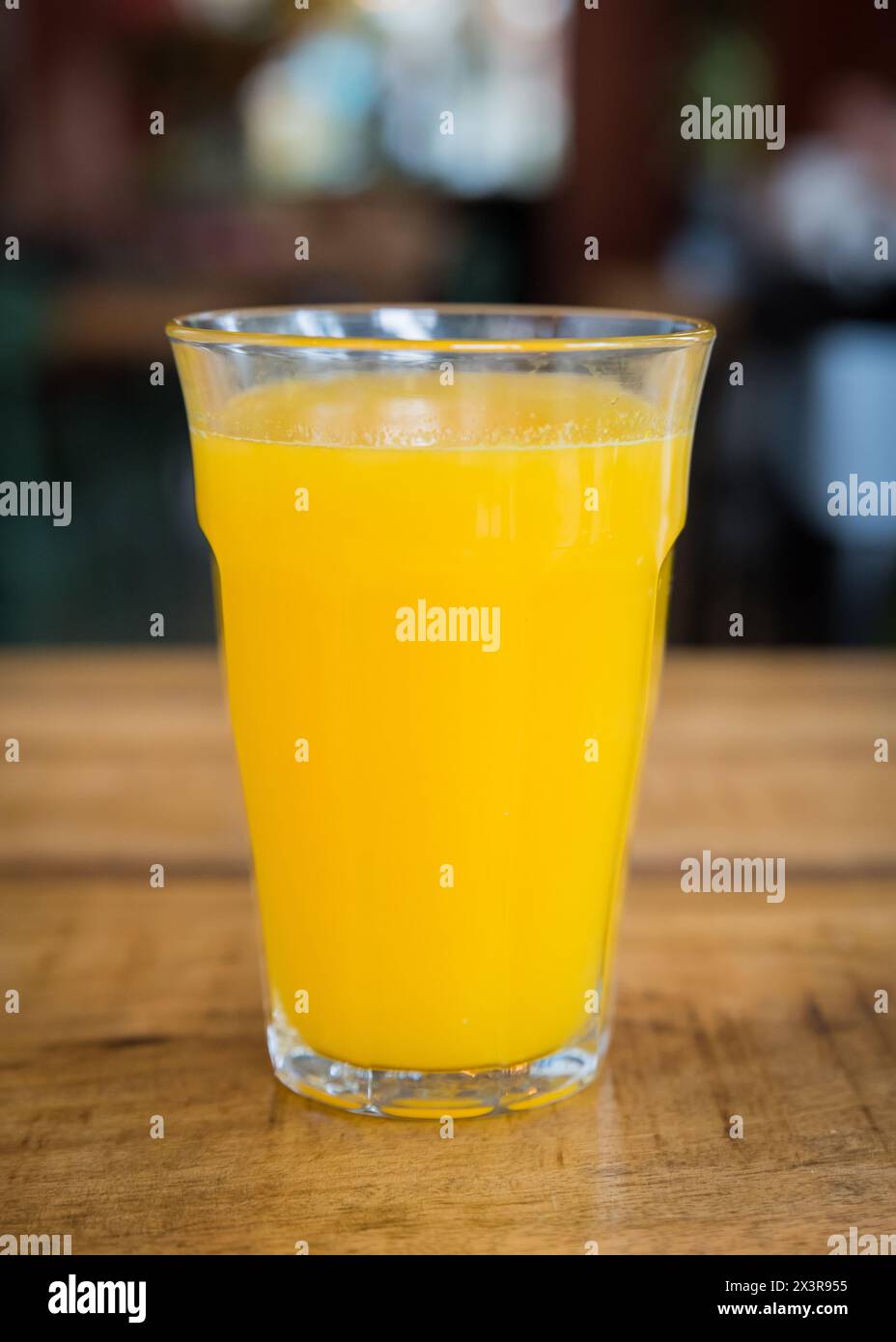 Jus d'orange fraîchement pressé dans un verre sur une table en bois dans un café restaurant Banque D'Images