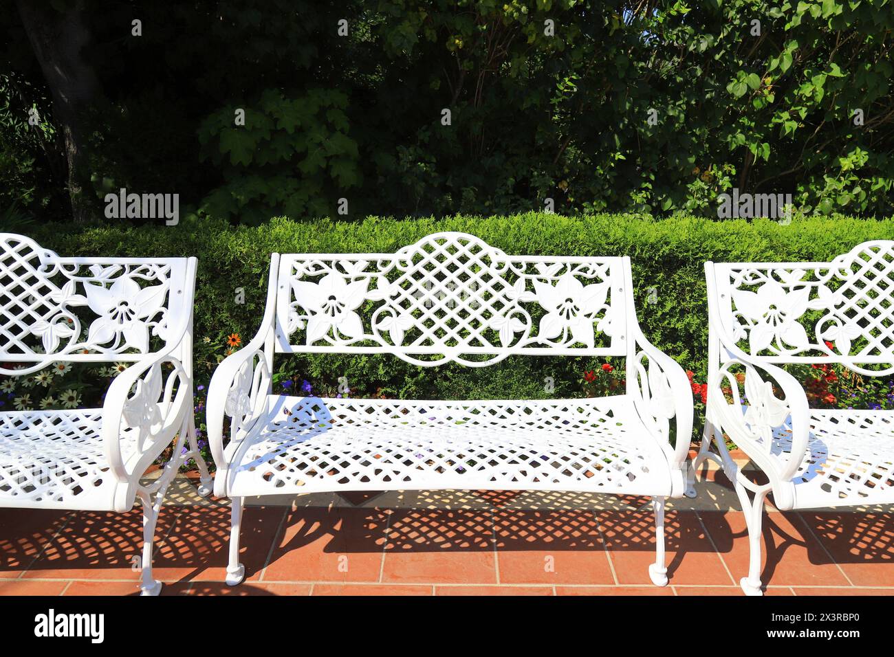 Mobilier de jardin d'été. Bancs blancs forgés rétro dans le café de rue sur la terrasse. Mobilier d'extérieur, beau banc ajouré dans le jardin. Banque D'Images